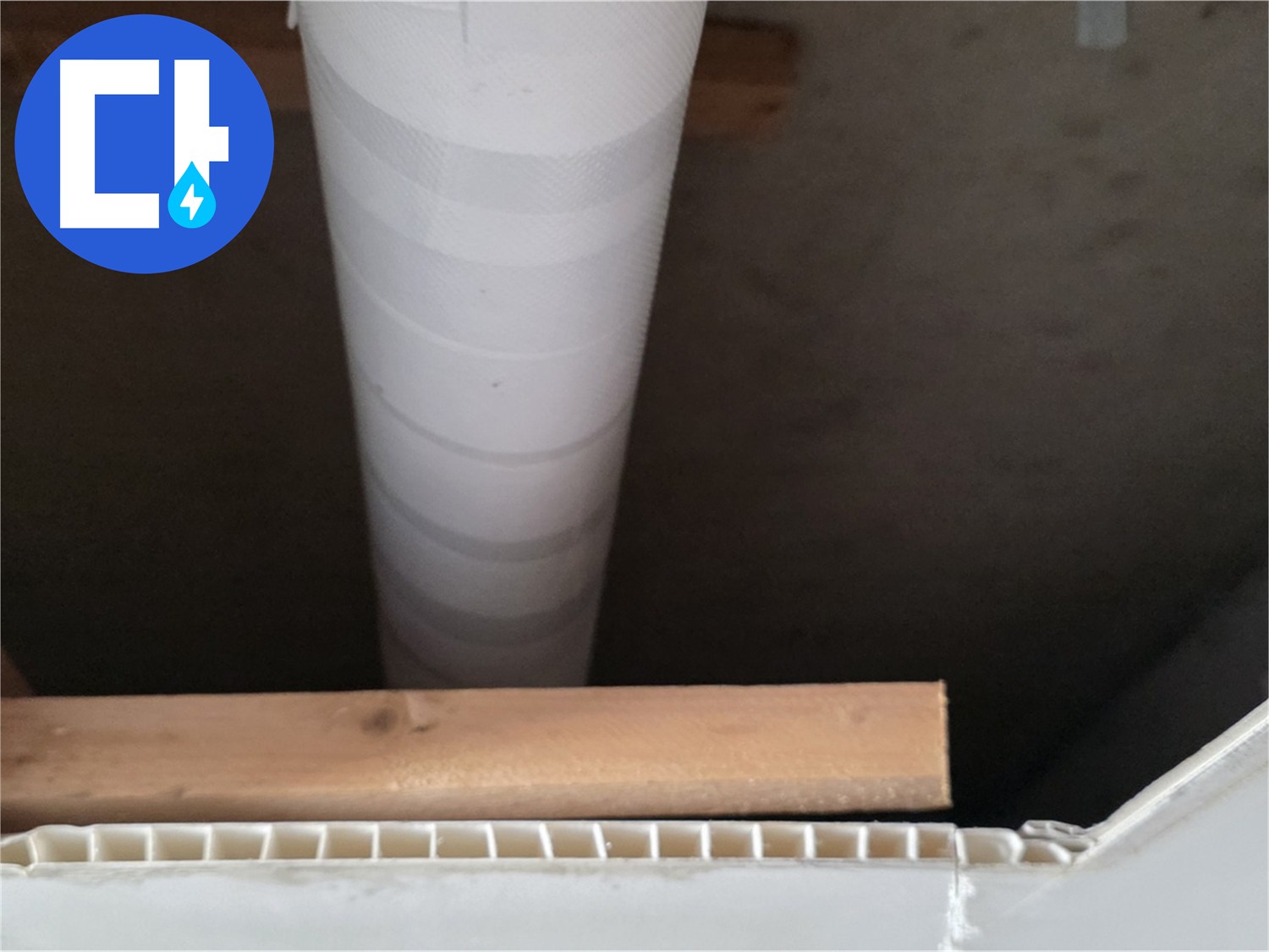 목재 구조물과 흰색 PVC 배관이 연결된 천장 내부 모습입니다.