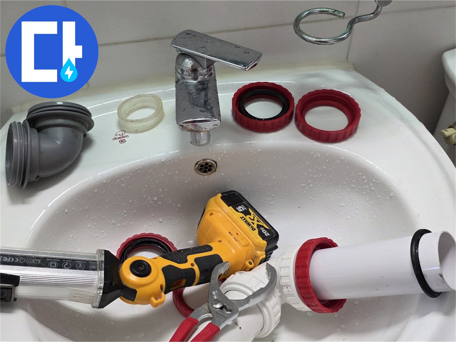 세면대 위에 나열된 PVC 엘보와 실란트 건 및 수전 부품