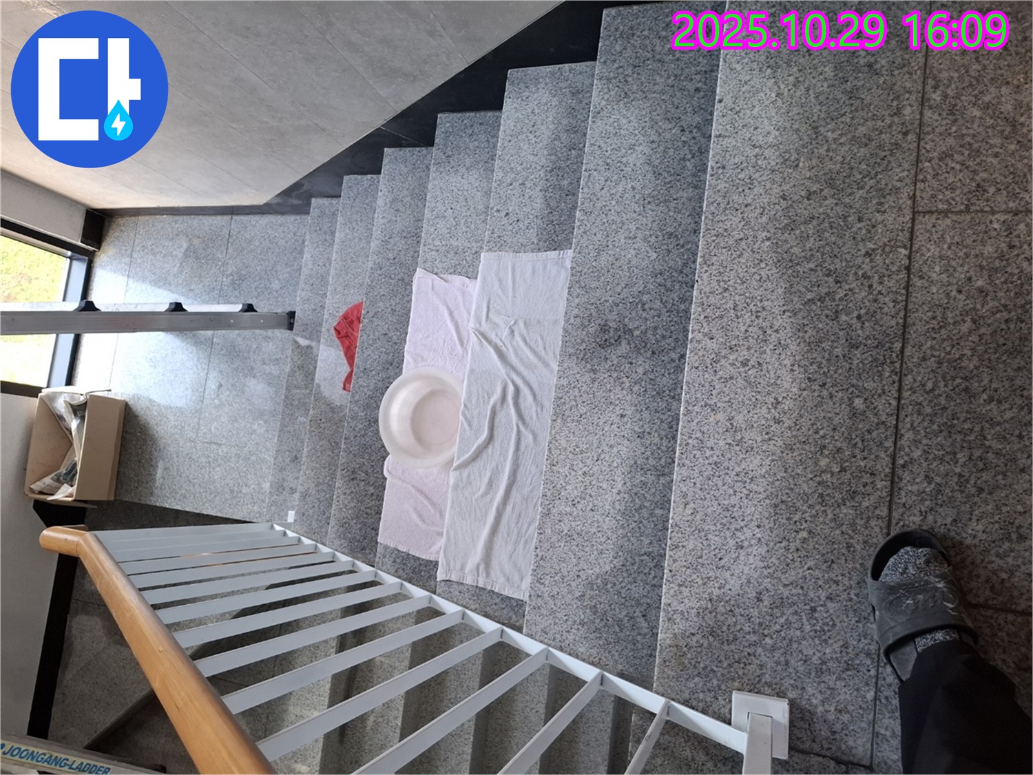 계단에 펼쳐진 수건과 대야 - 심각한 누수 상황을 보여줍니다.