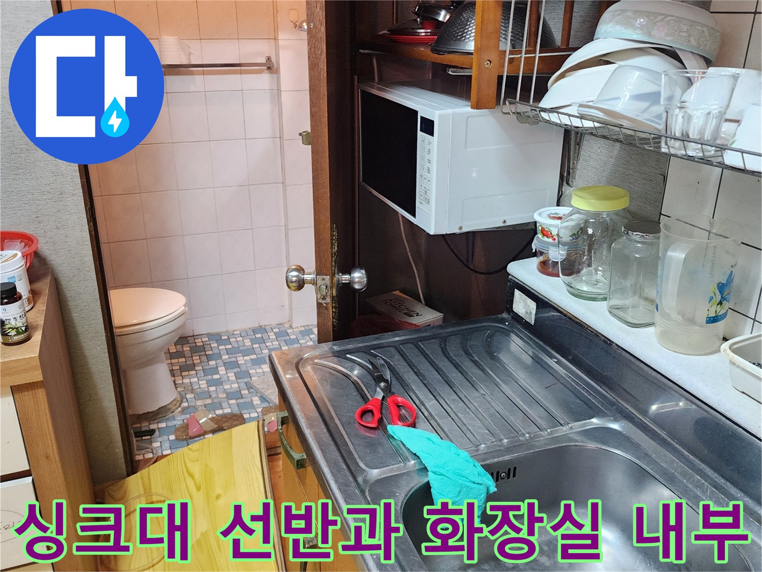 그릇이 놓인 싱크대와 연결된 화장실 입구