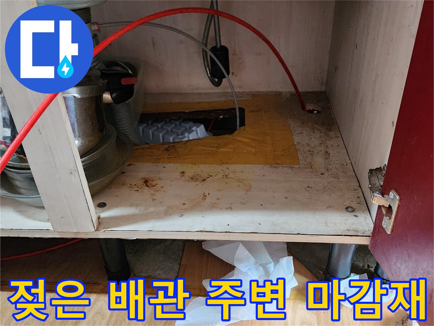 싱크대 하단 배관 부근의 젖어있는 나무 판재 사진