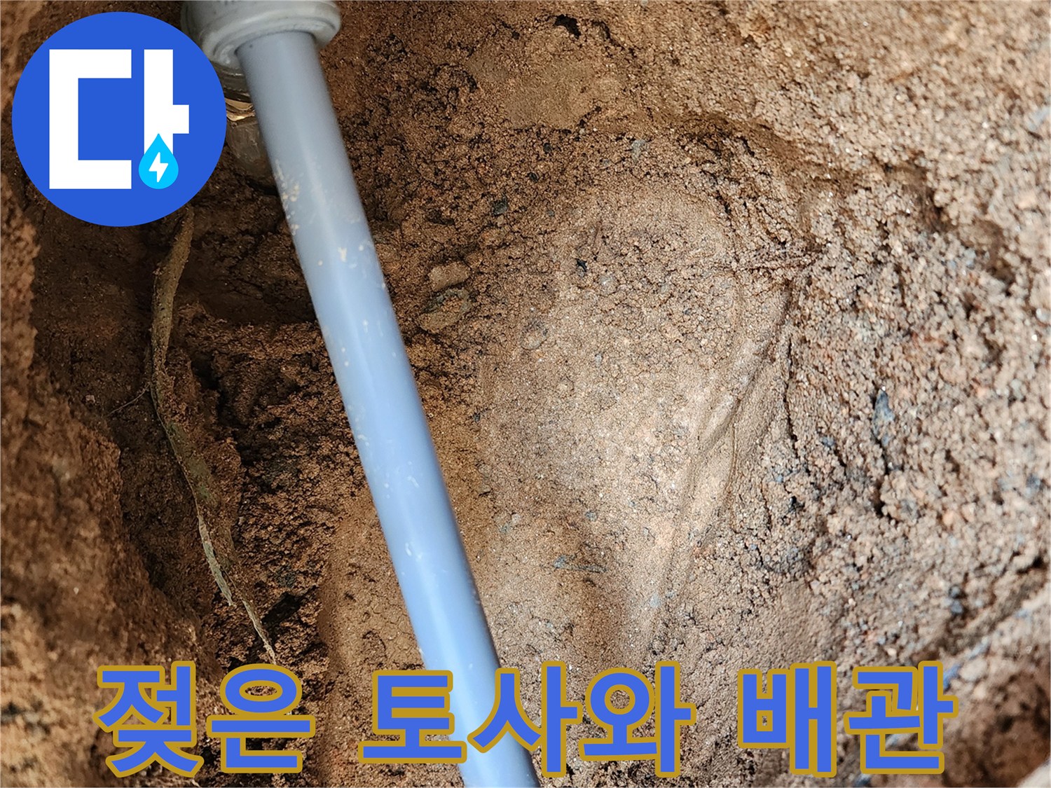 파란색 배관-주변의 젖은 흙과 누수 흔적
