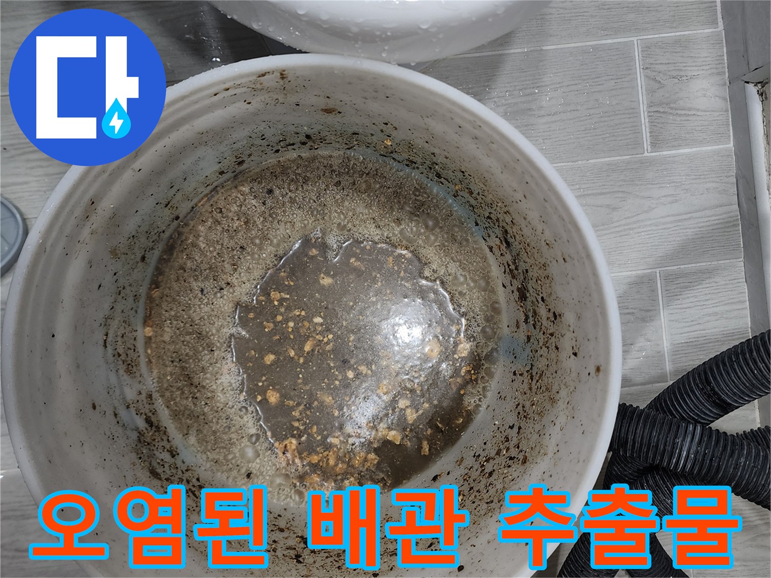 양동이에 담긴 탁한 색의 배관 오염수와 찌꺼기