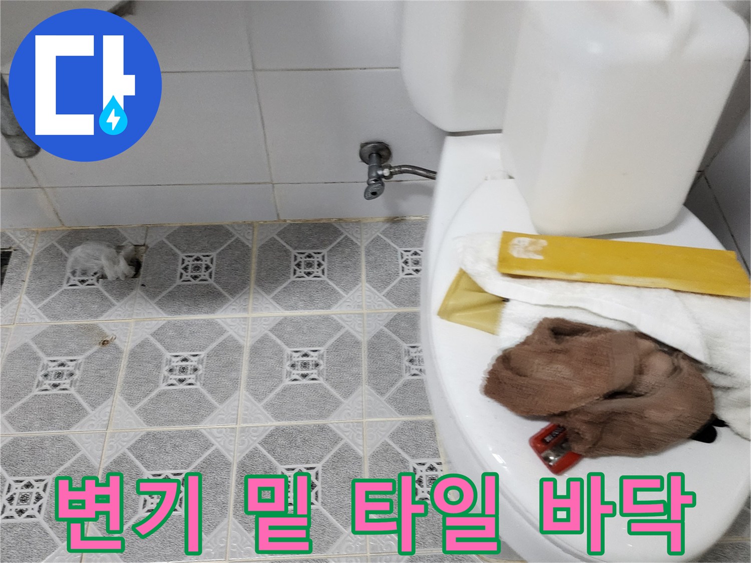 변기 하단 타일과 배관 연결 부위 근접 사진입니다.