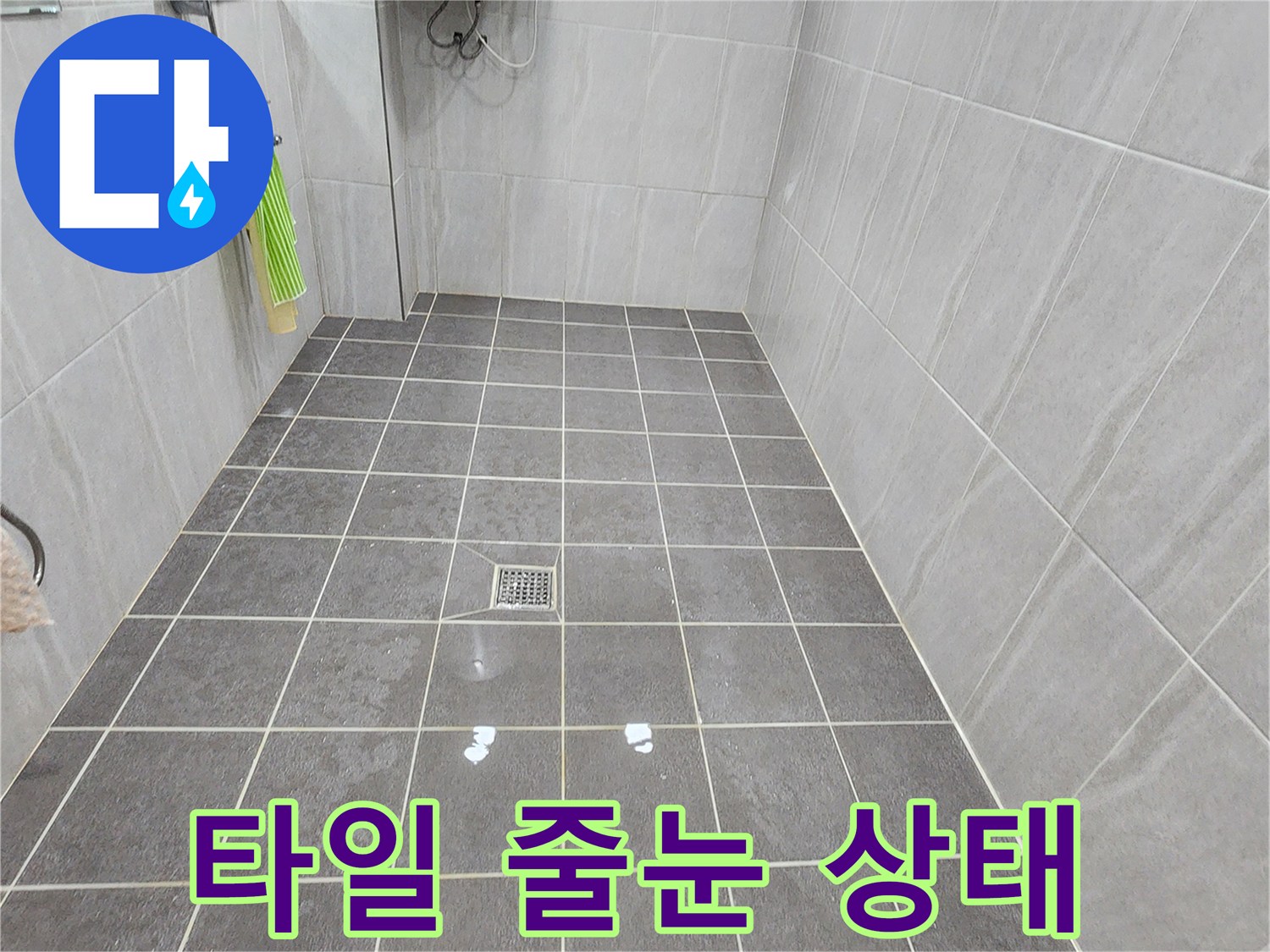 물기가 묻어있는 욕실 바닥 타일과 배수구 사진