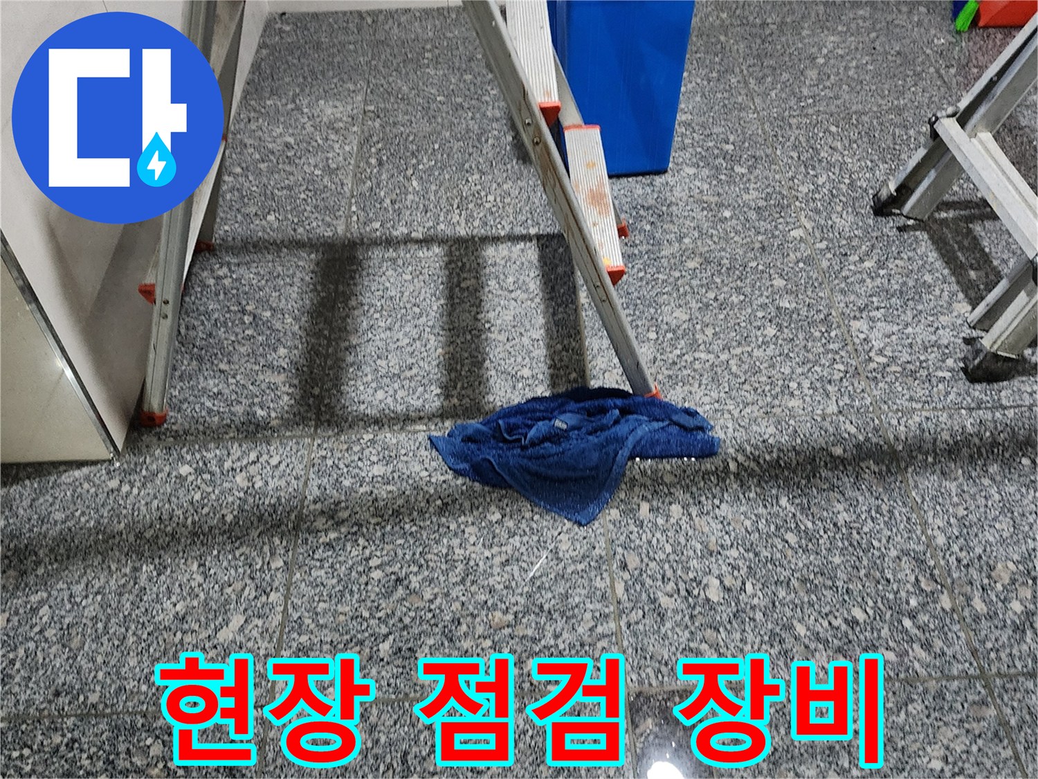 사다리와 파란 양동이가 놓인 현장 타일 바닥