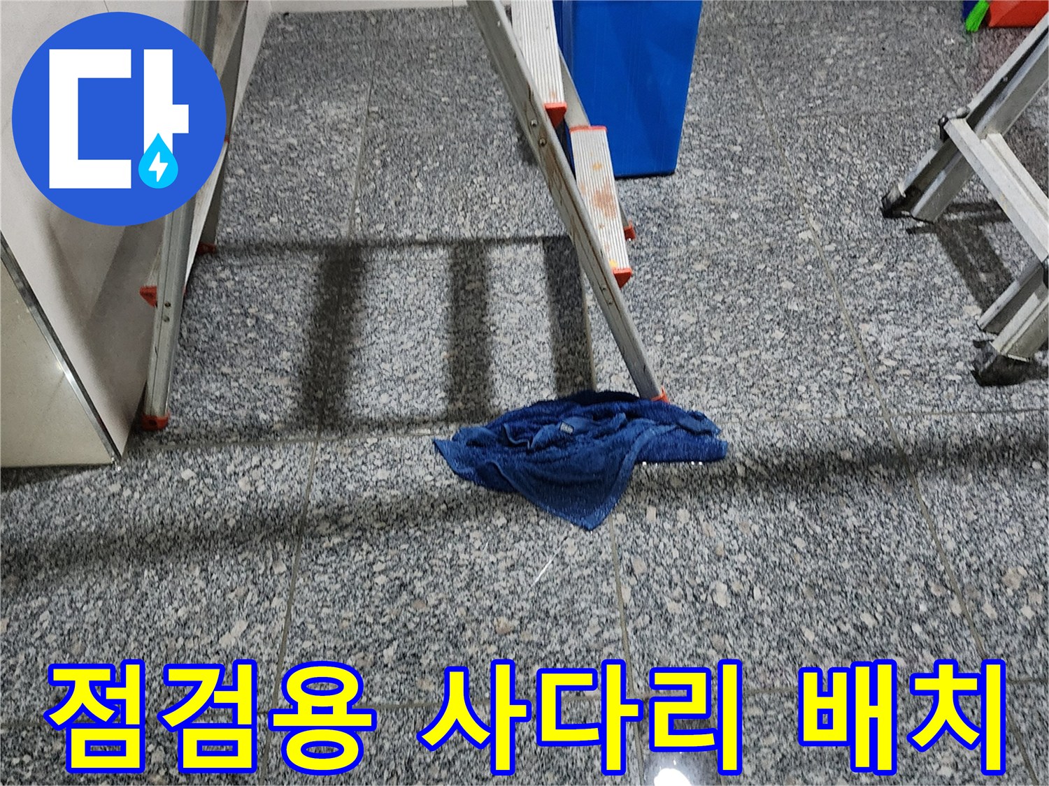 사다리와 파란색 통이 놓여 있는 작업 현장 바닥