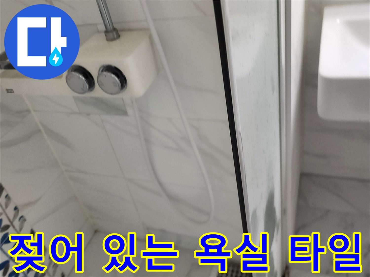 샤워기 수전 하단의 젖은 벽면 타일 모습