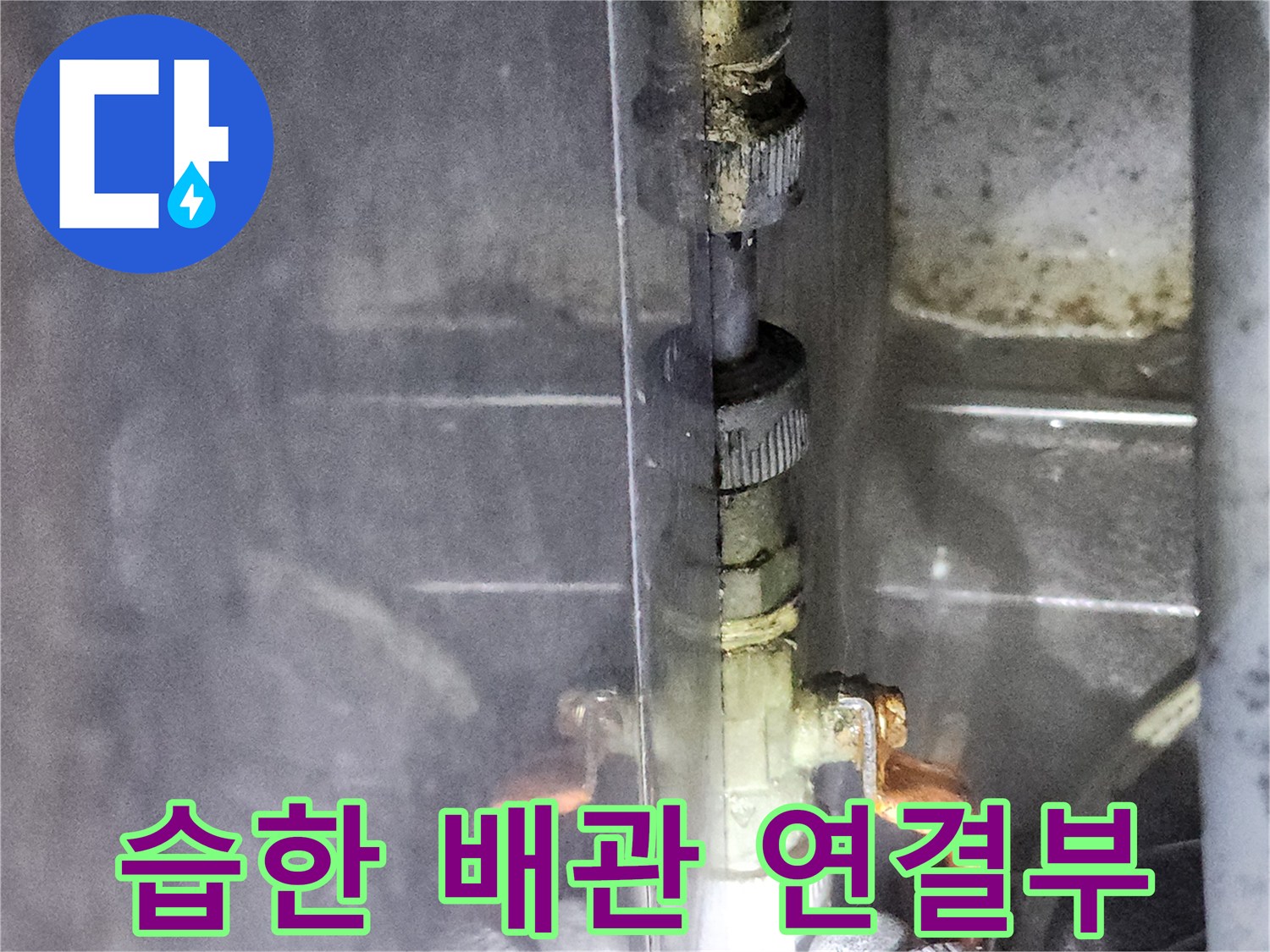 물기가 맺혀 있는 금속 수도 배관 연결 부위입니다.