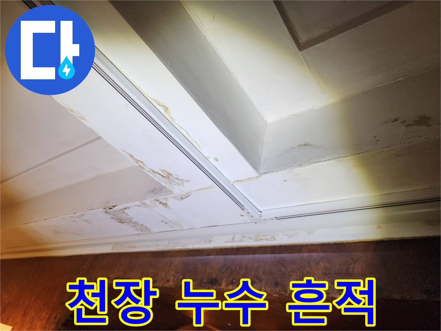 천장 마감재 사이로 번진 갈색 물 얼룩 사진