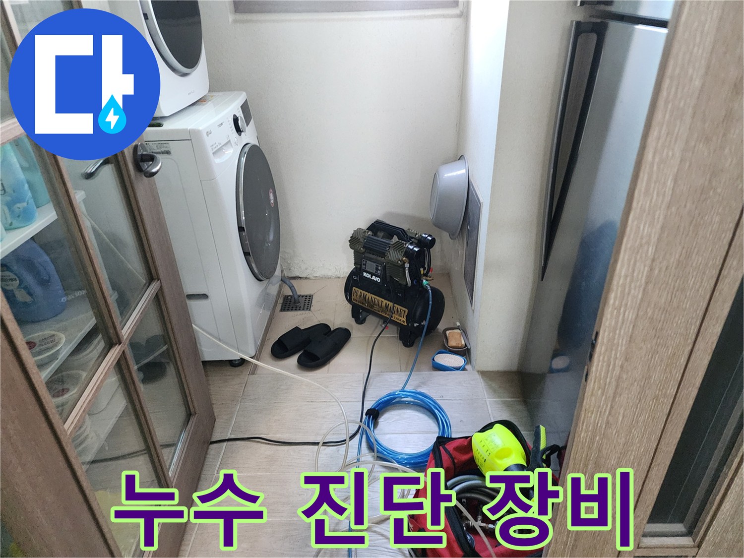 세탁실 바닥의 검은색 탐지기와 파란색 전선 릴