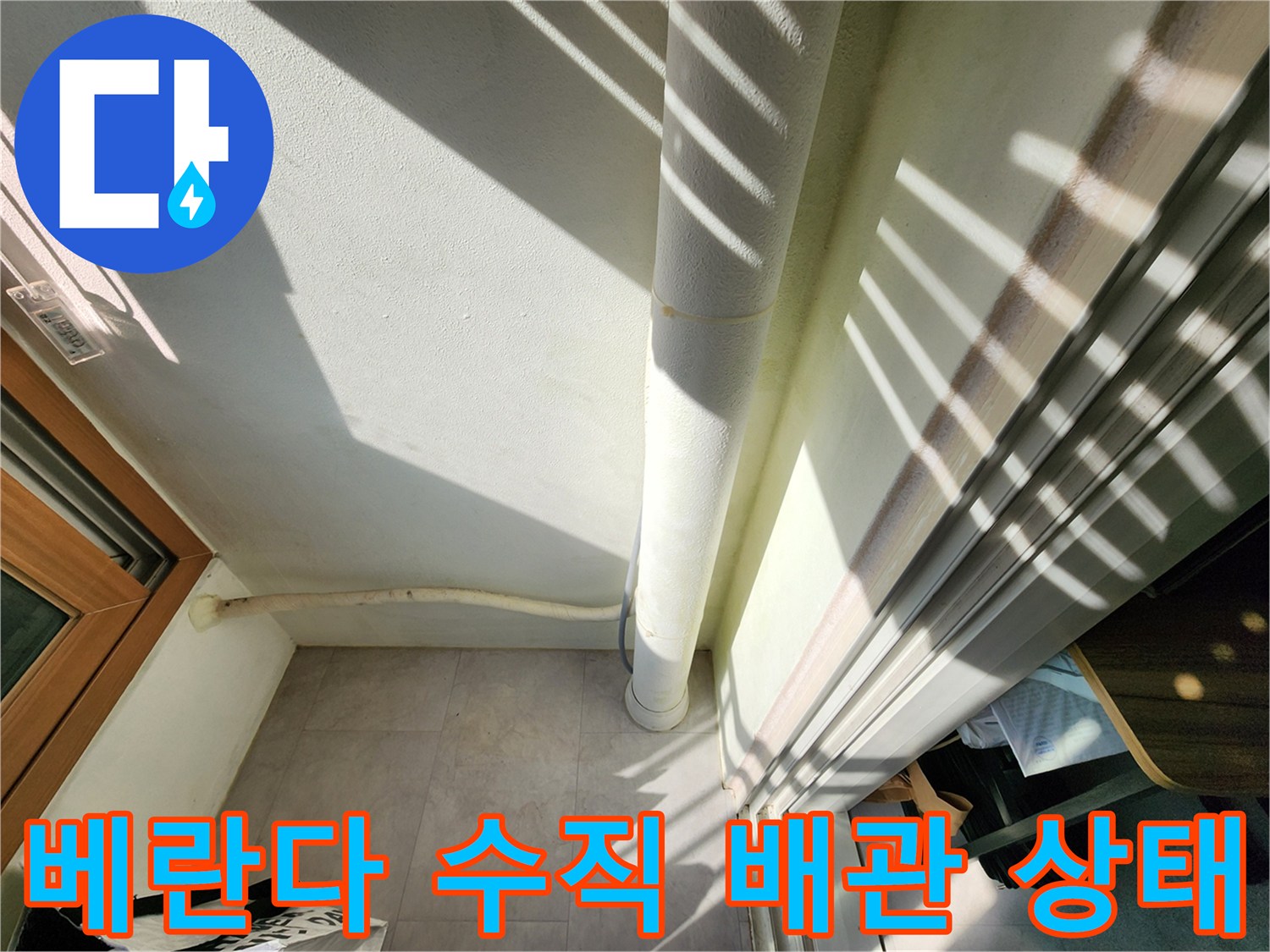 수직 배관 하단부의 젖은 벽면 촬영 사진