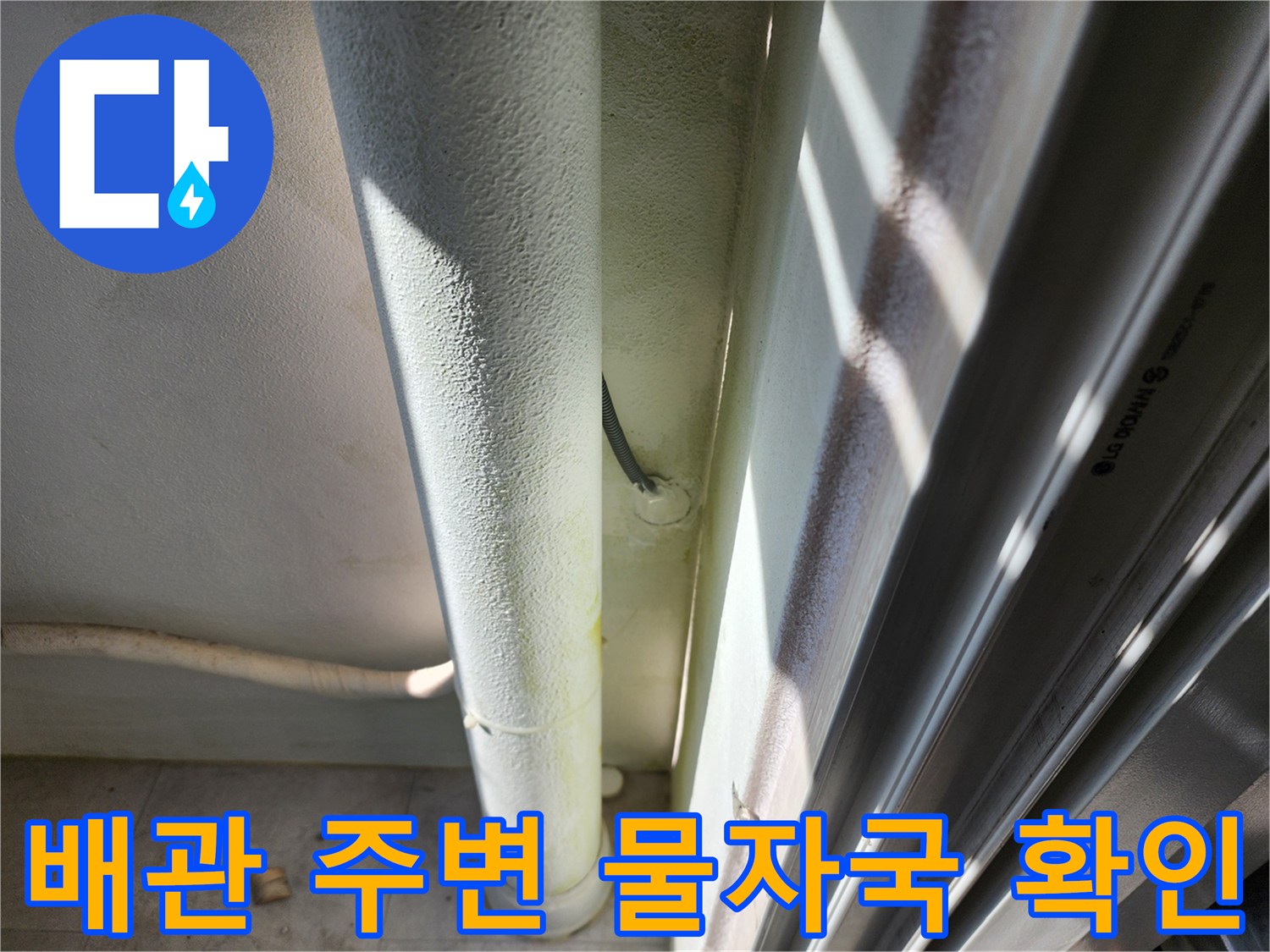 하얀색 배관 아래 벽면의 젖은 흔적