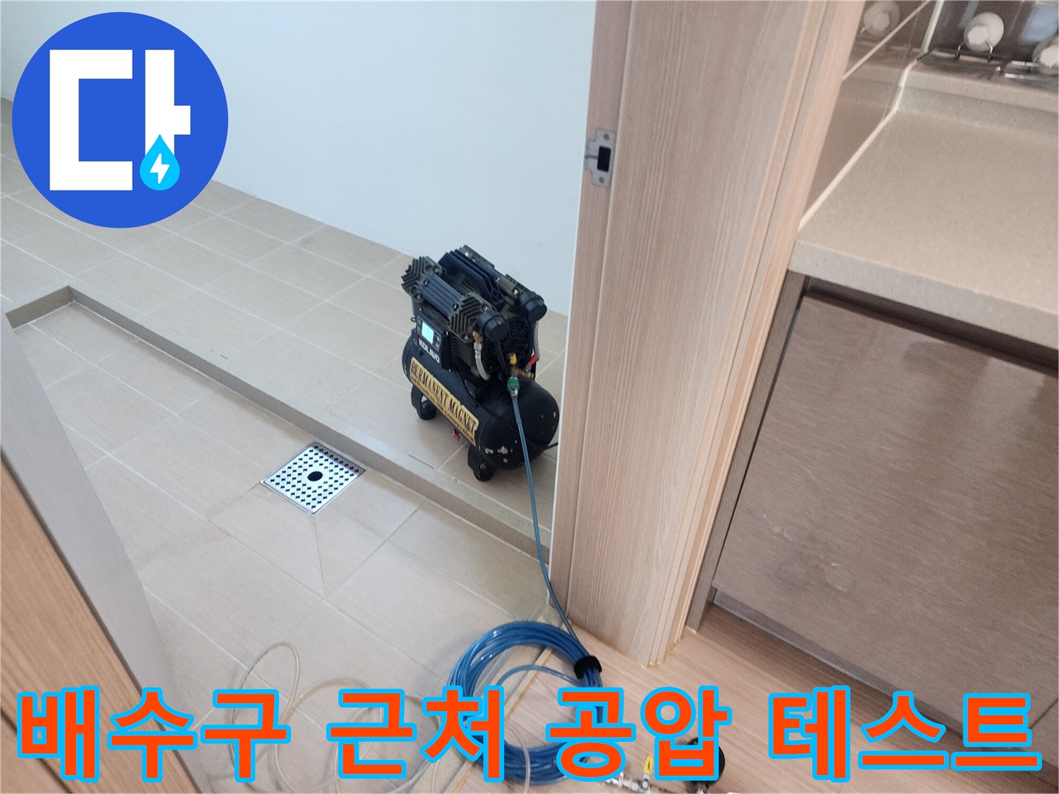바닥 배수구와 연결된 파란색 호스와 압력 측정 장치