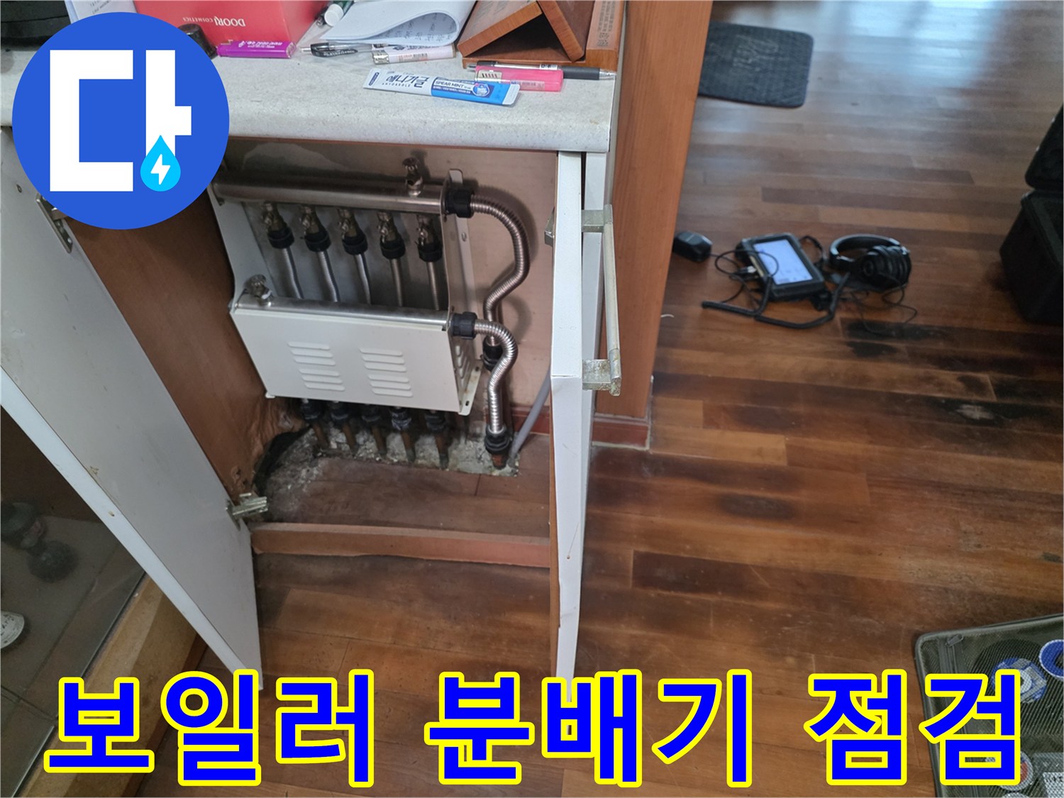 싱크대 하부장에 위치한 보일러 분배기와 연결 배관 사진