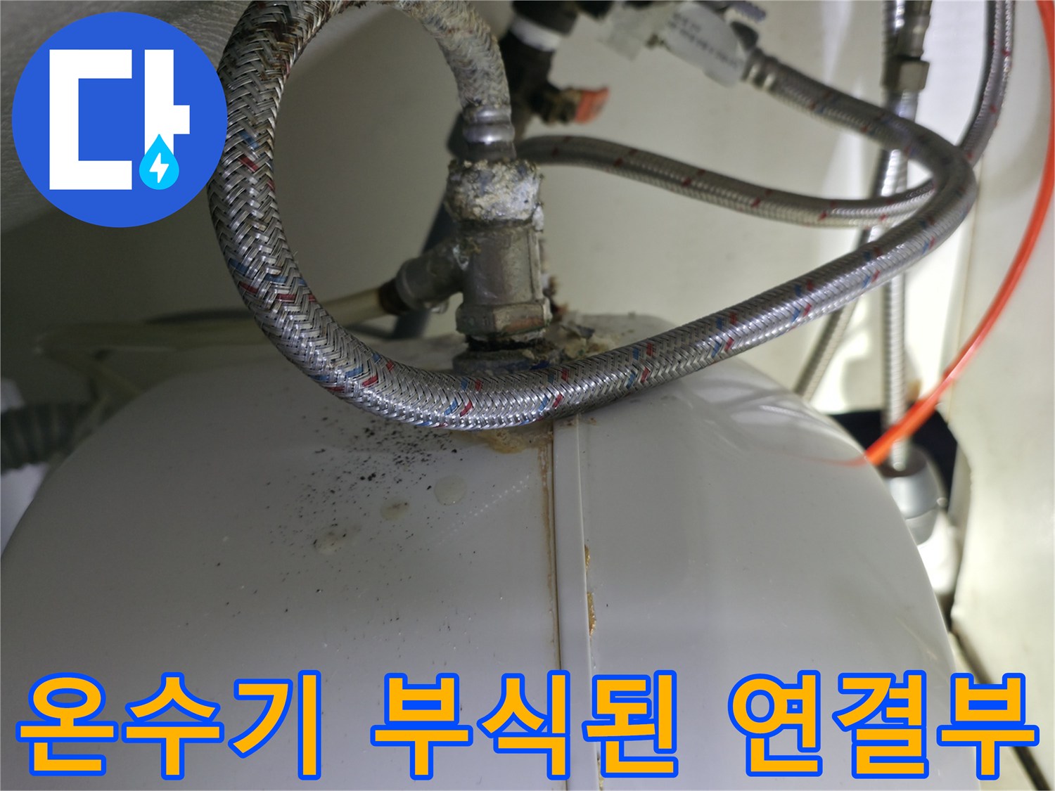 온수기 하부 - 녹물이 맺힌 금속 배관 연결 지점