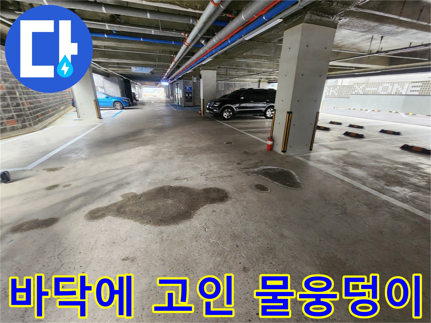 지하 주차장 바닥 면의 넓은 물 자국과 웅덩이