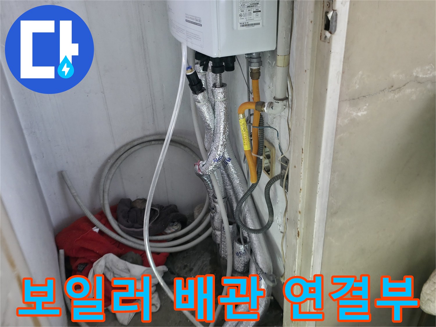 보일러 아래쪽의 은색 보온재로 감싸진 배관 구조물