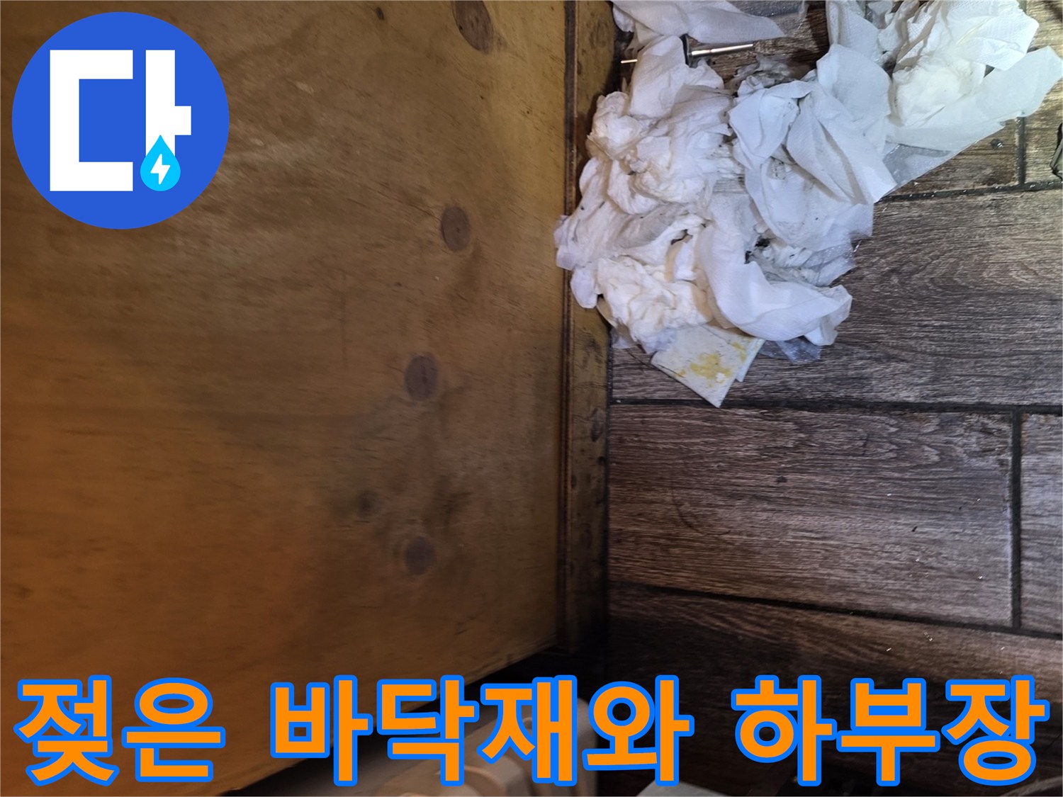 나무 소재의 하부장 밑부분과 젖어 있는 바닥 자재