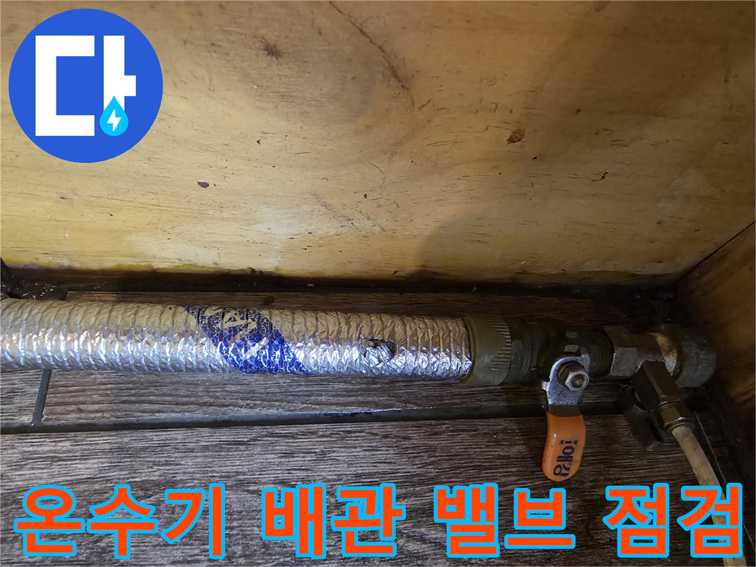 보온재 감긴 배관 - 주황색 밸브와 금속 부속 근접 사진