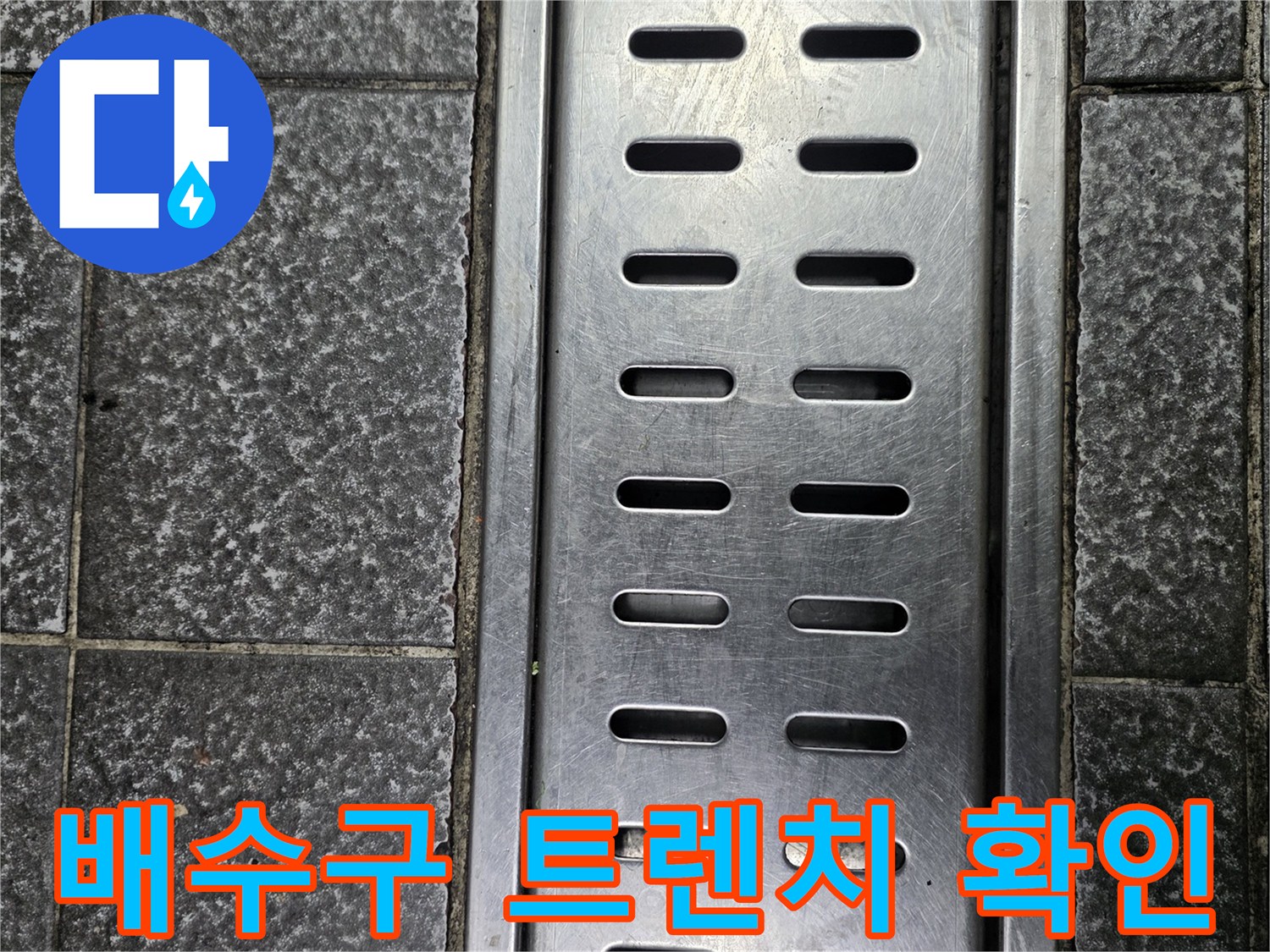 스테인리스 재질의 배수구 덮개와 타일 바닥