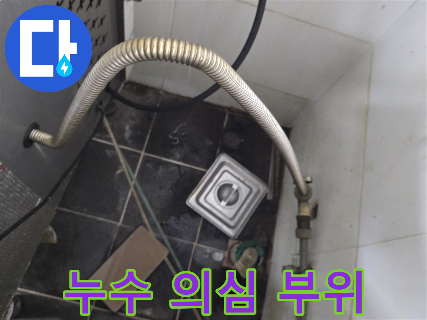 온수기 하단 자바라 배관과 젖은 타일 바닥