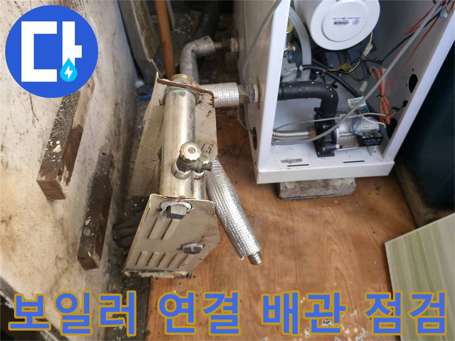보일러 하단의 금속 배관 및 컨트롤 유닛 모습