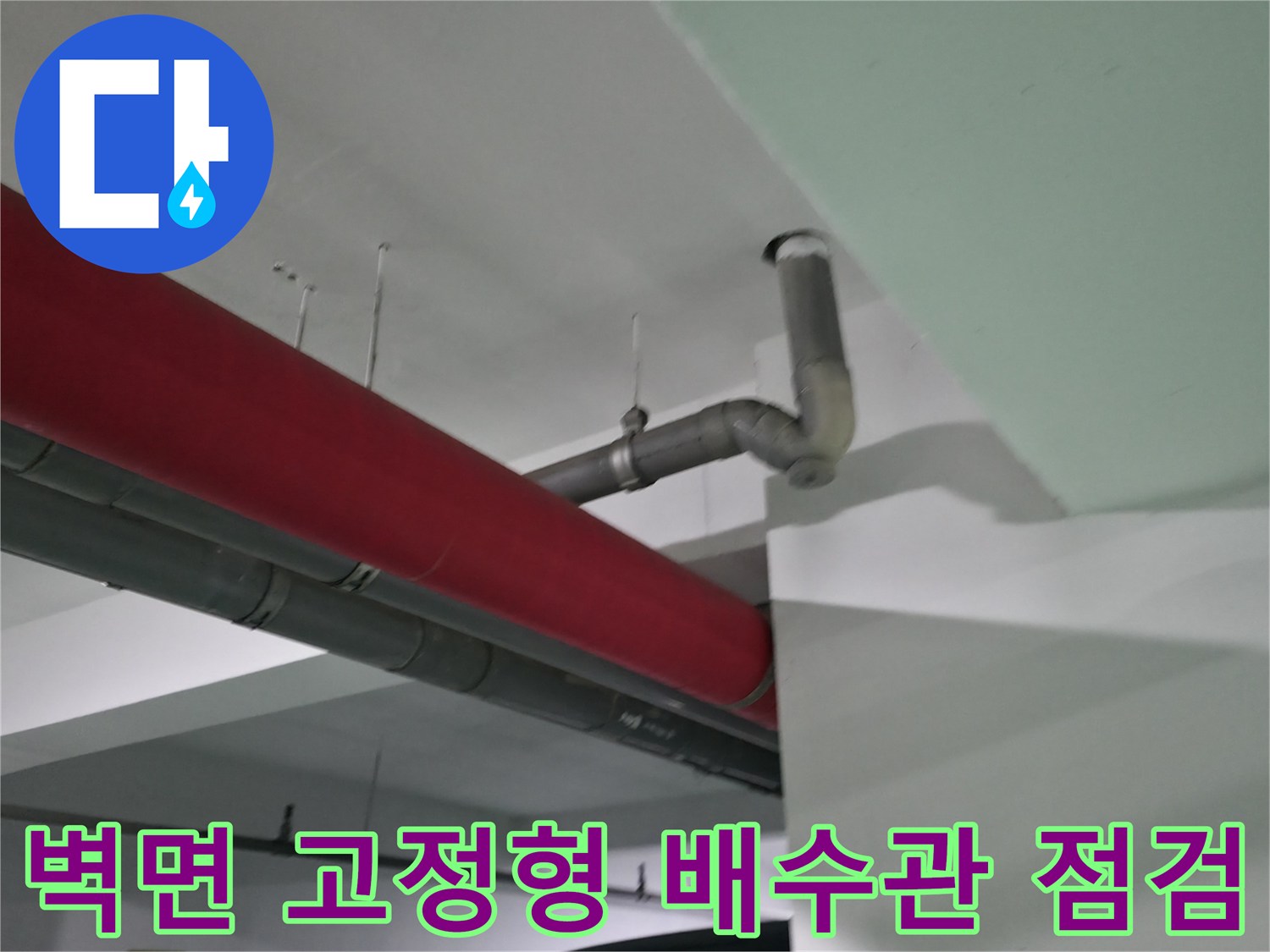 붉은색 마감재와 회색 배기구 및 배수관의 결합부