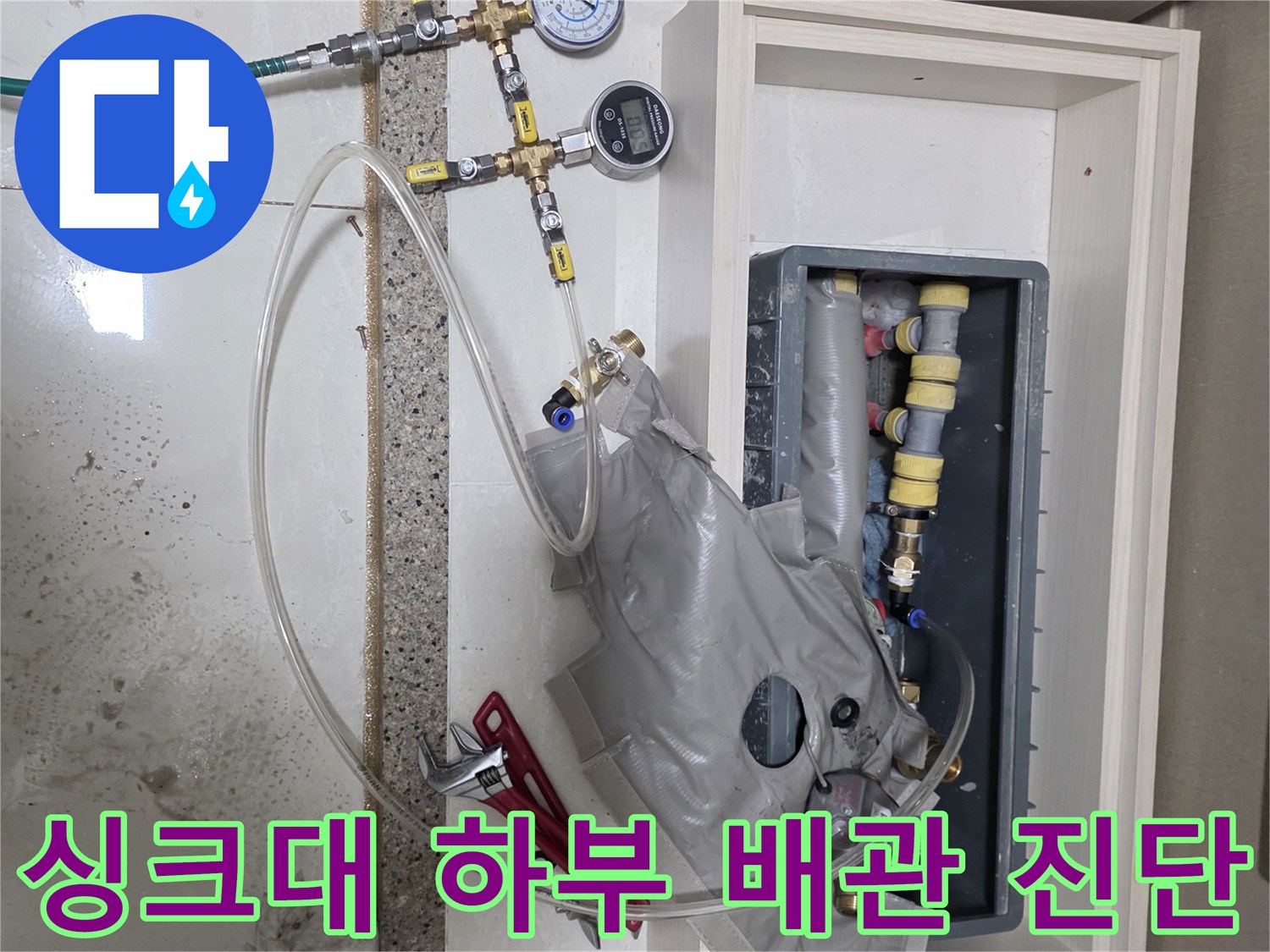 싱크대 아래 분배기에 연결된 압력계와 튜빙 호스
