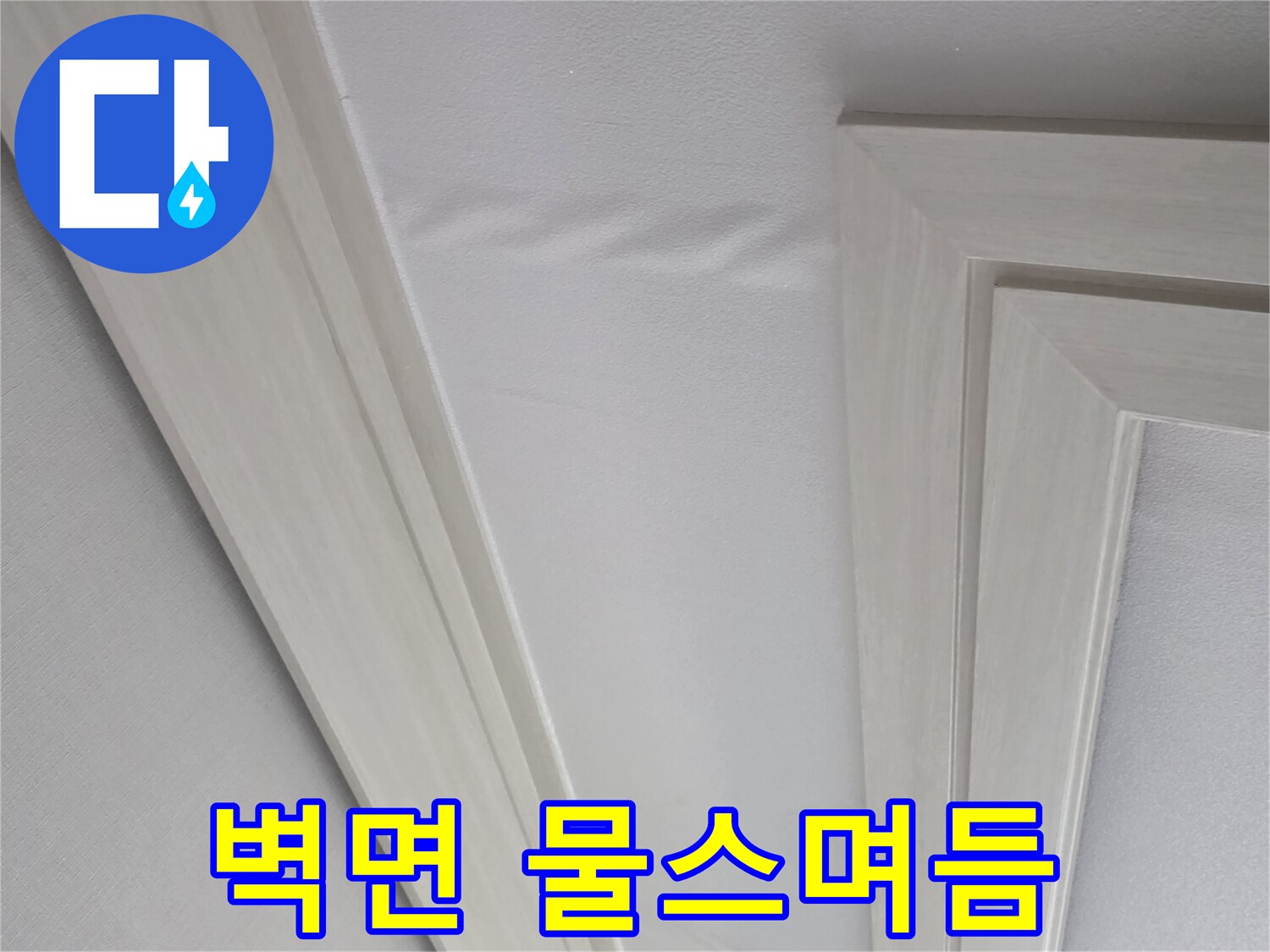 하얀색 몰딩 아래쪽 벽지의 젖은 변색 부위