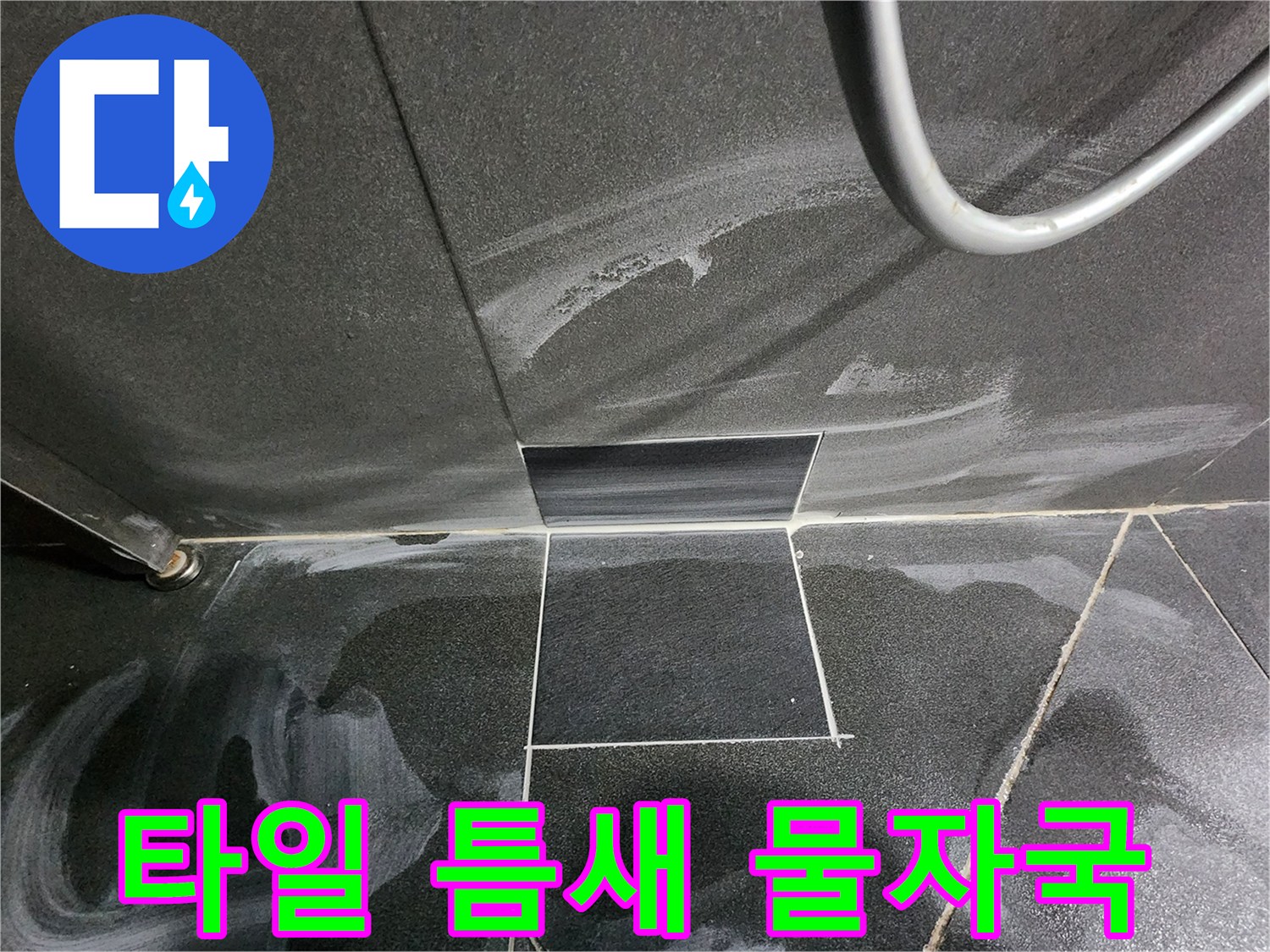 어두운색 타일 사이의 하얀 누수 흔적