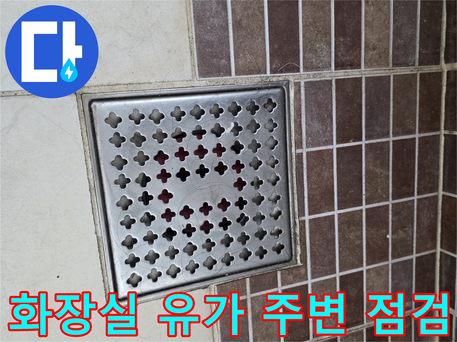 스테인리스-배수구-덮개와-갈색-벽면-타일