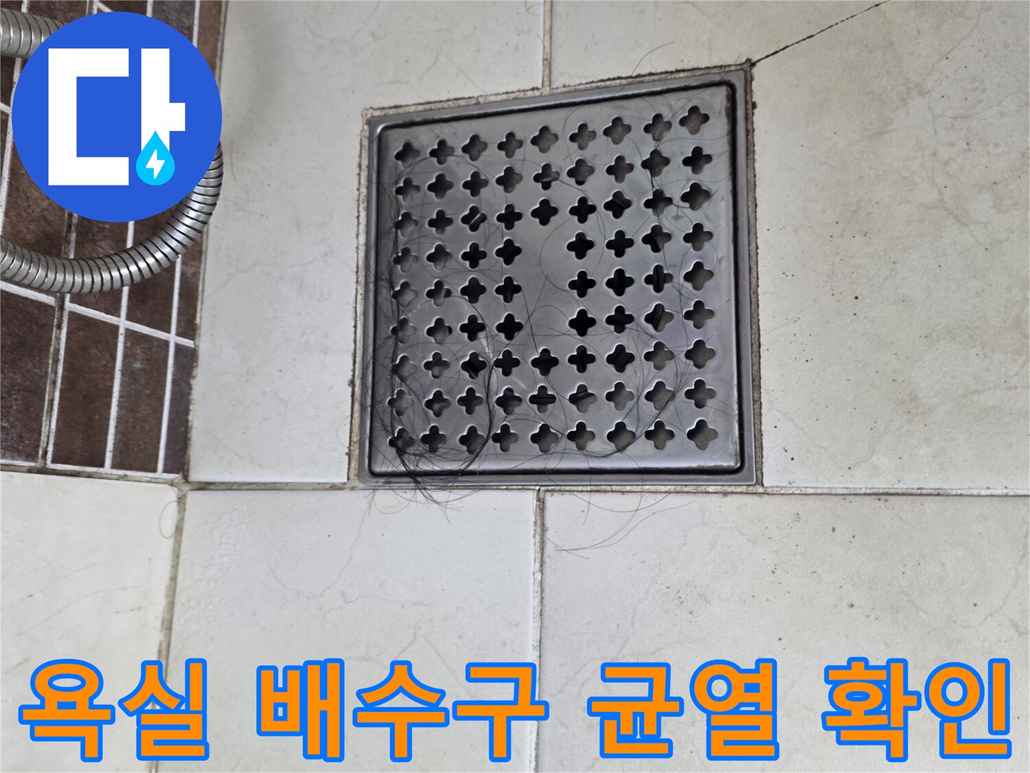 욕실 바닥 배수구 주변의 갈라진 타일 부위