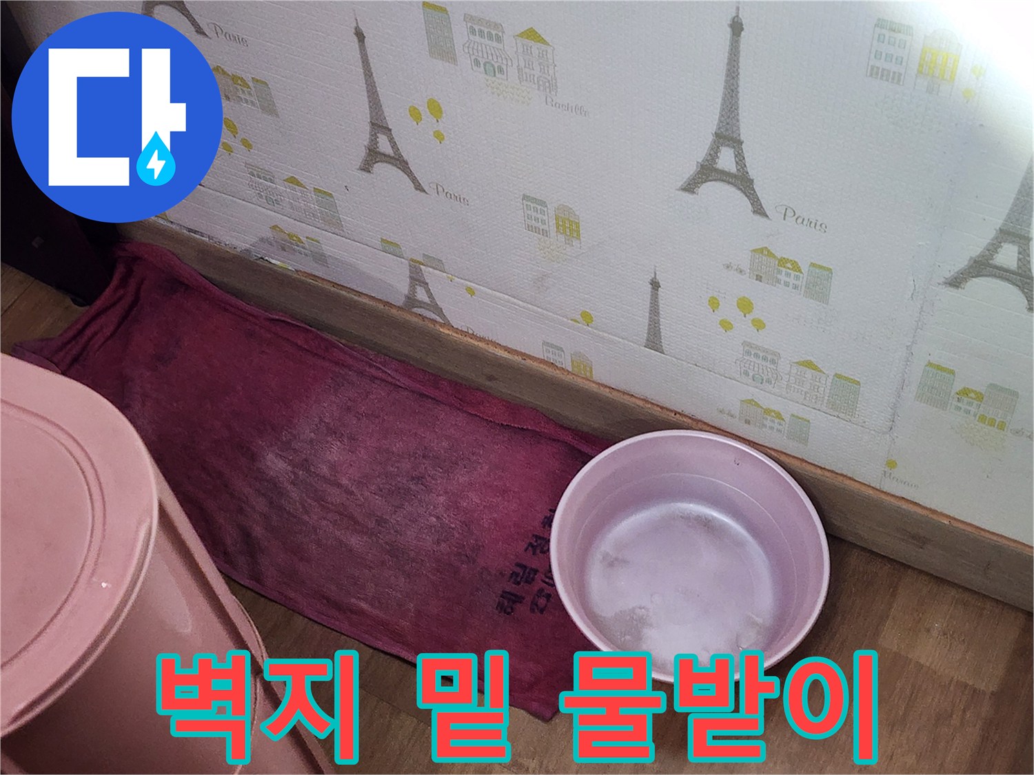 누수 현장 모습-벽면 하단의 대야와 젖은 천