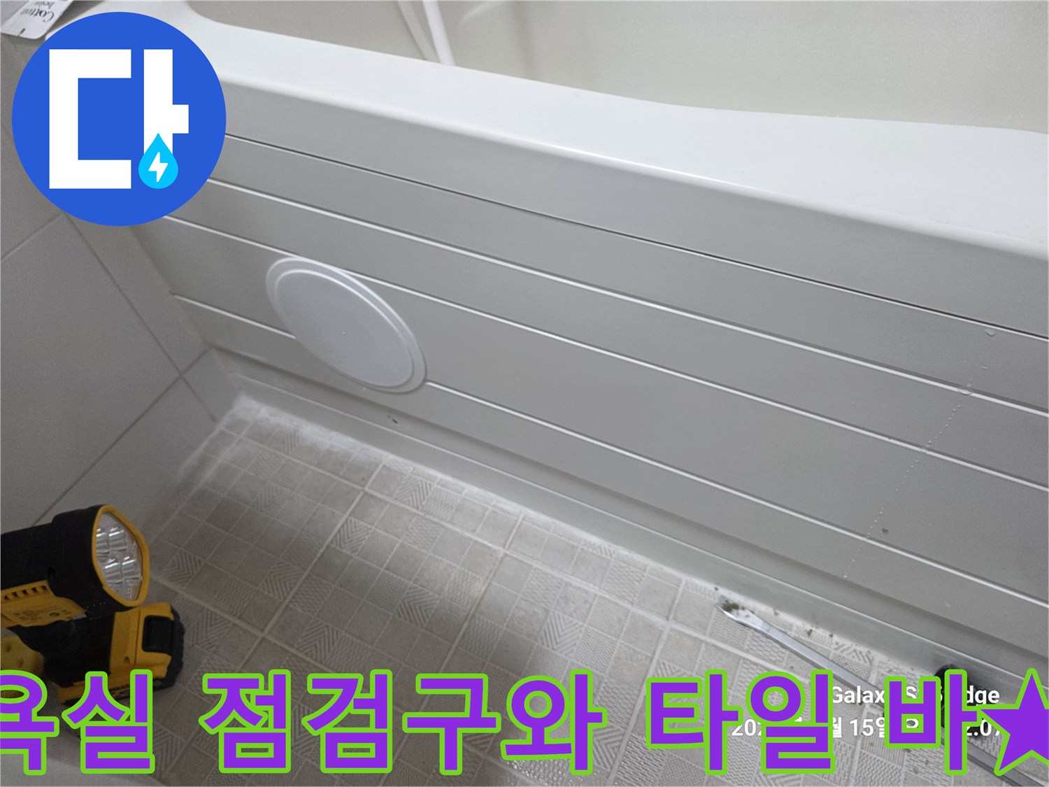 흰색 욕조 벽면의 둥근 점검구 부위 사진