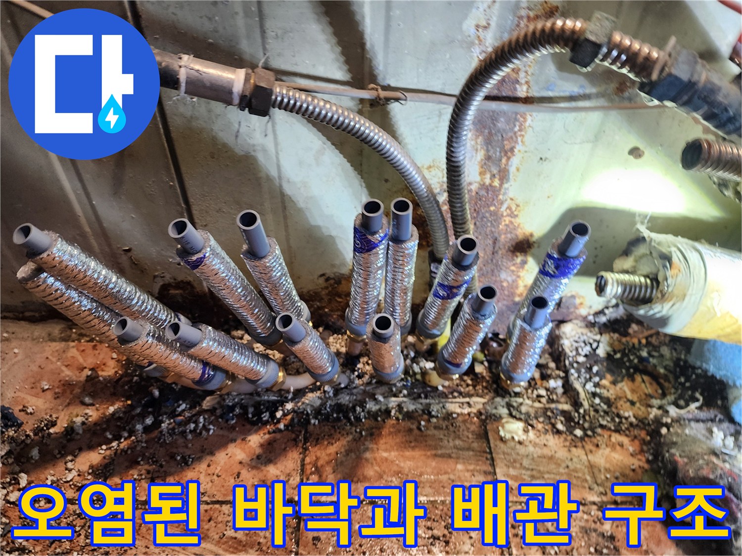 누수로 인해 변색된 타일과 배관 연결부