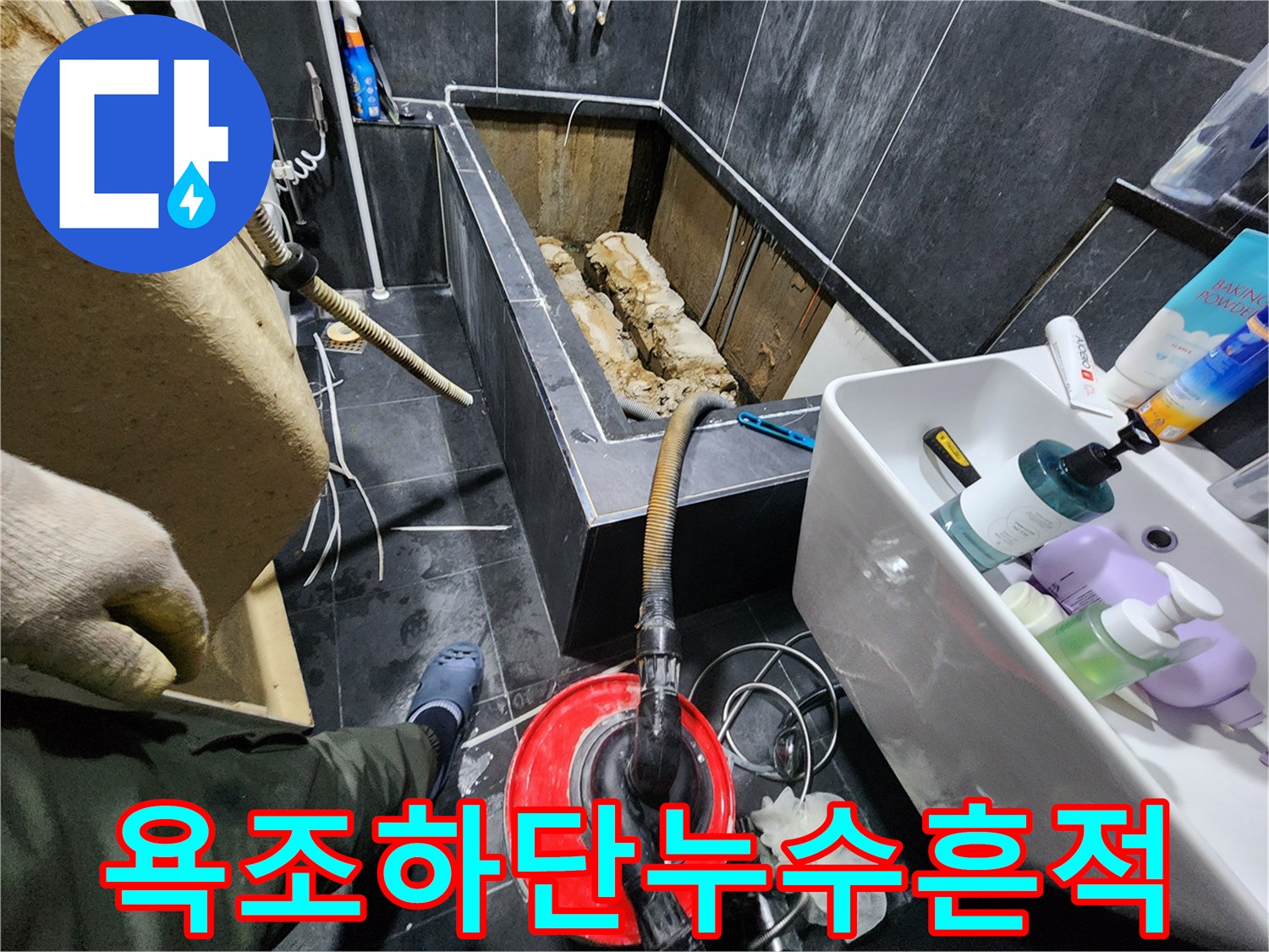 물에 젖은 채 노출된 욕조 하부 배관의 모습