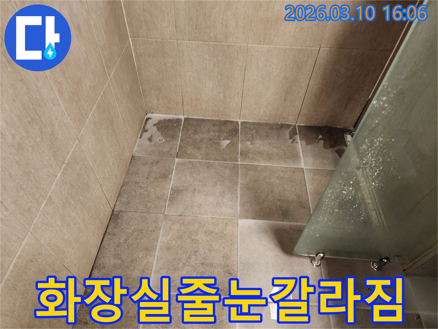화장실 바닥 타일 줄눈이 갈라져-물이 스며드는 현장을 보여주는 이미지입니다.