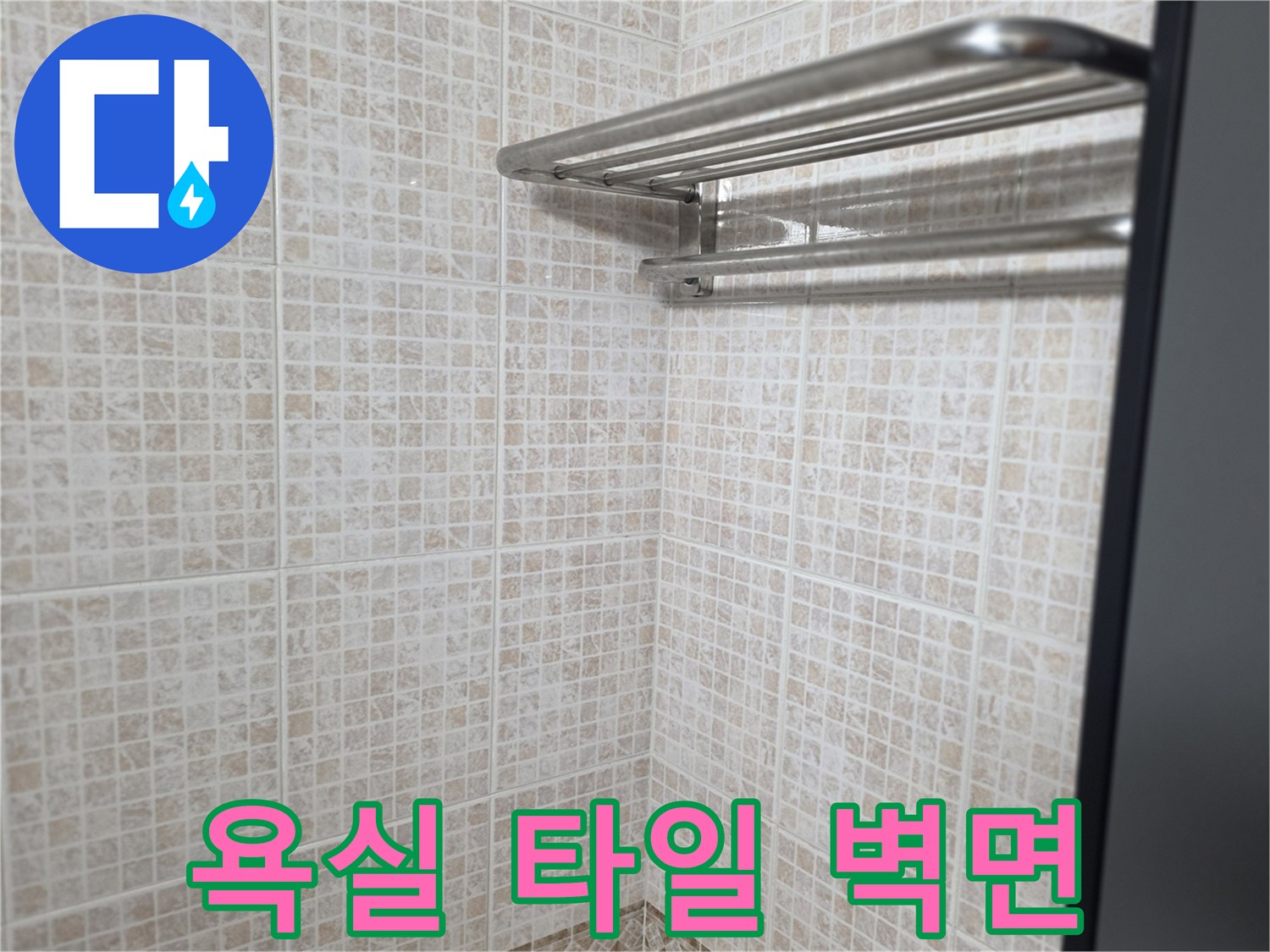 수건걸이가 설치된 밝은 색상의 욕실 타일