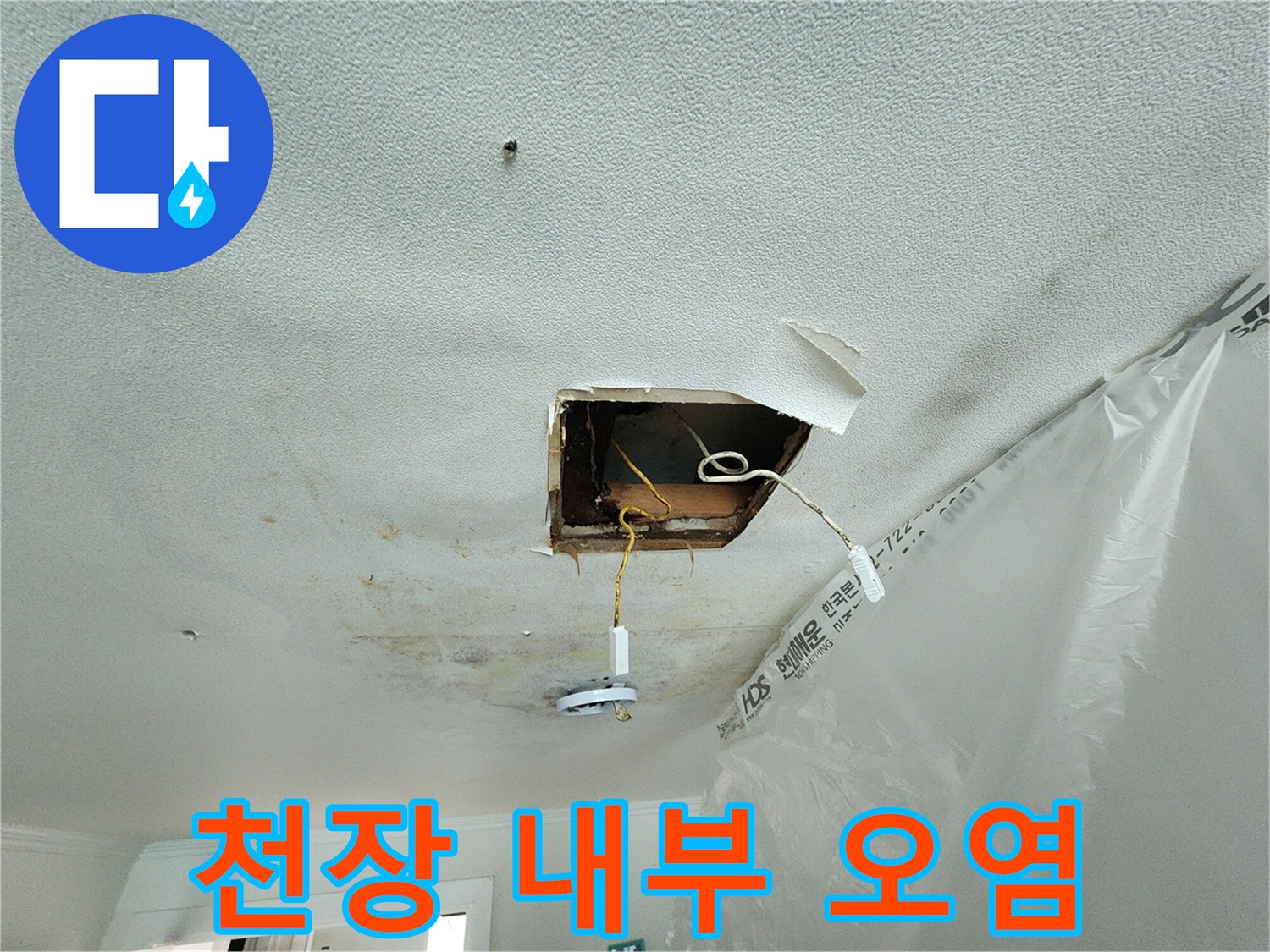천장 절개 부위의 젖은 흔적과 노출된 배선