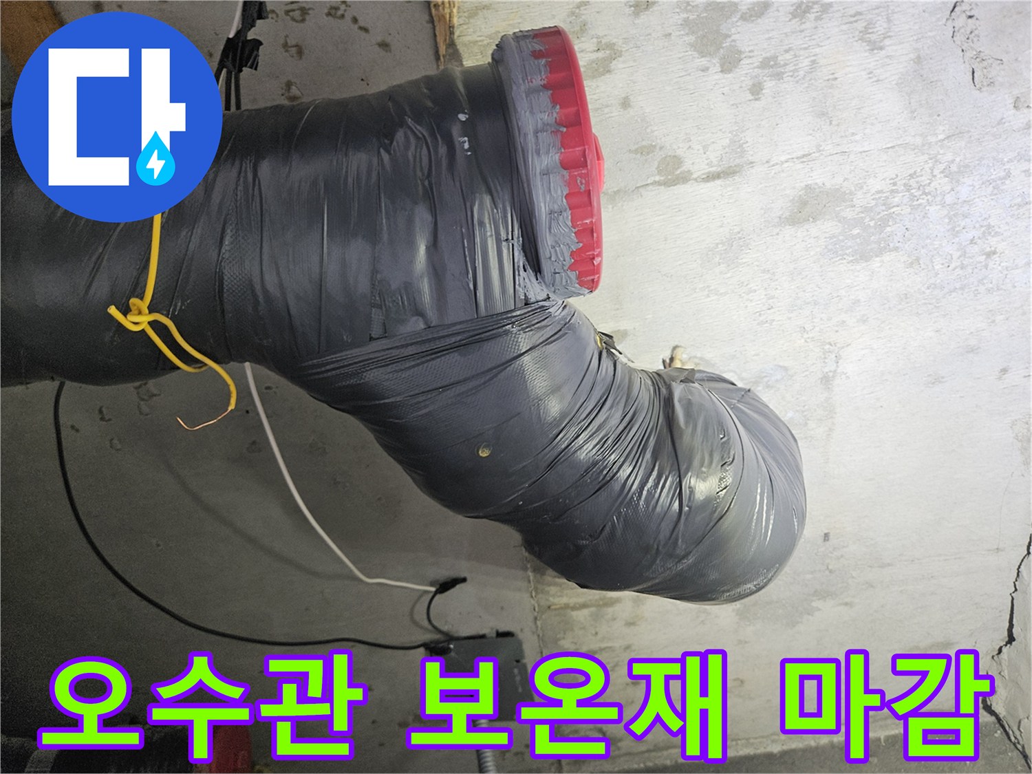 검은색 보온재로-덮여 있는 오수 배관 연결부