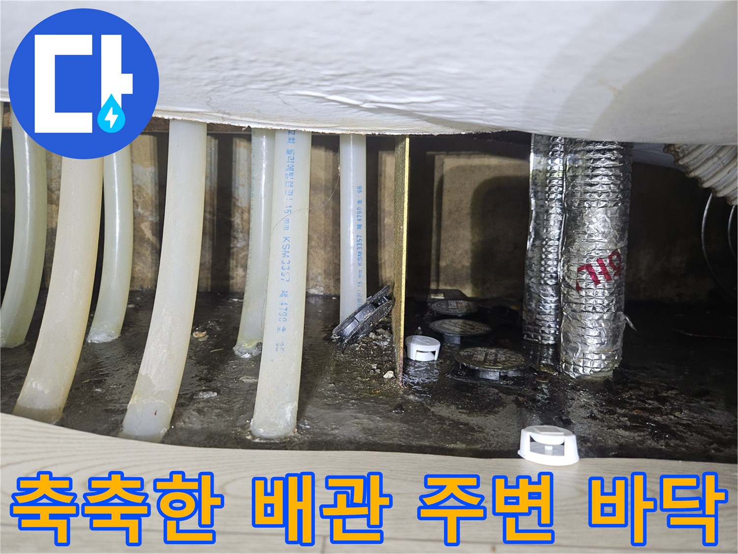 싱크대 하단 배관 주위의 젖은 바닥과 습기 찬 모습
