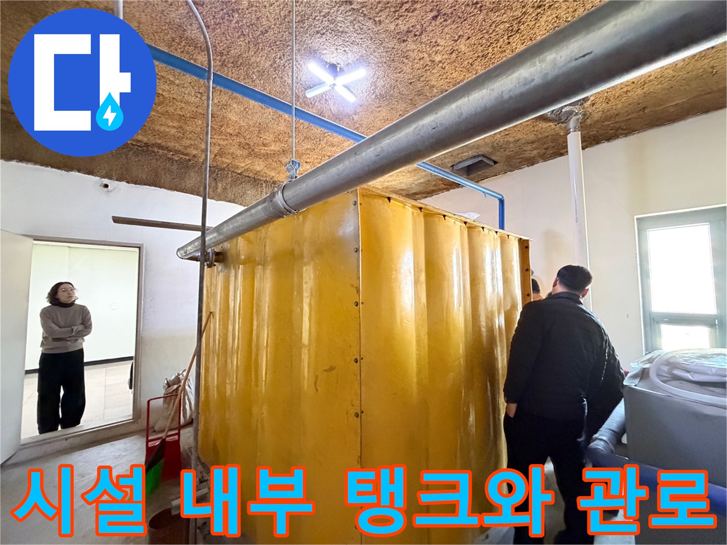 대형-노란색-탱크와-천장에-연결된-금속-배관