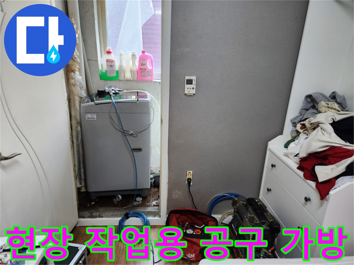 바닥에 놓인 빨간색 공구함과 파란색 배관 호스