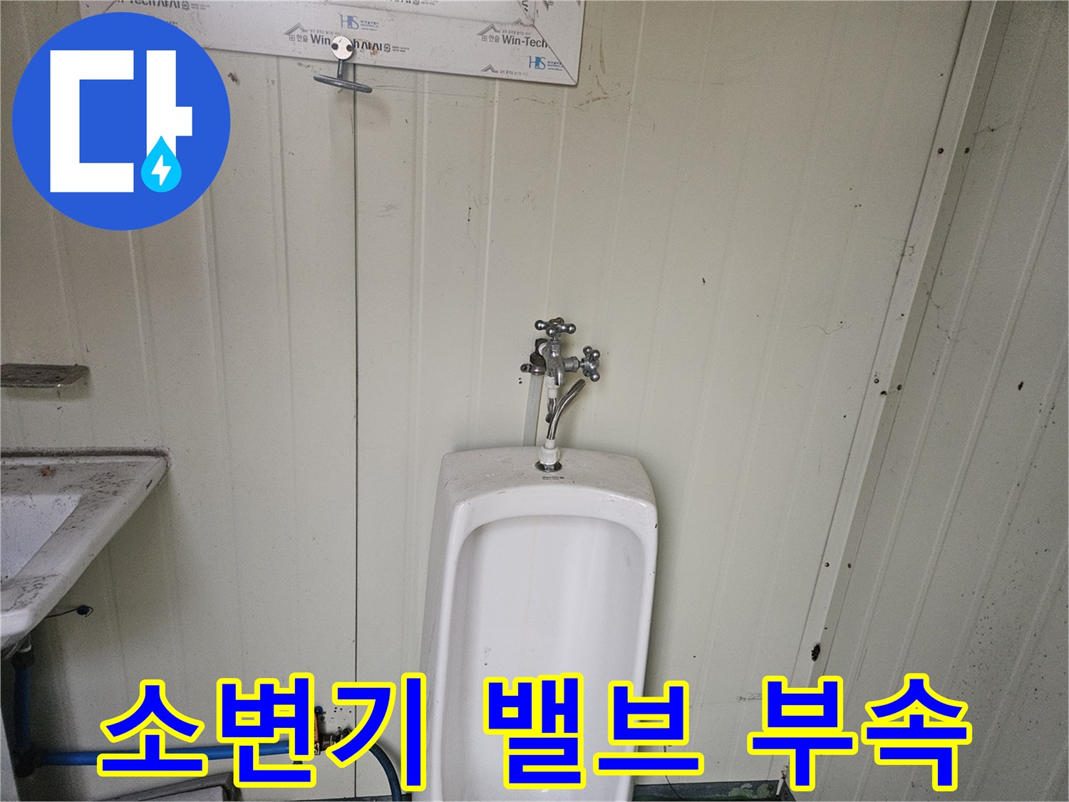 소변기 상단-금속 재질의 수전 연결부