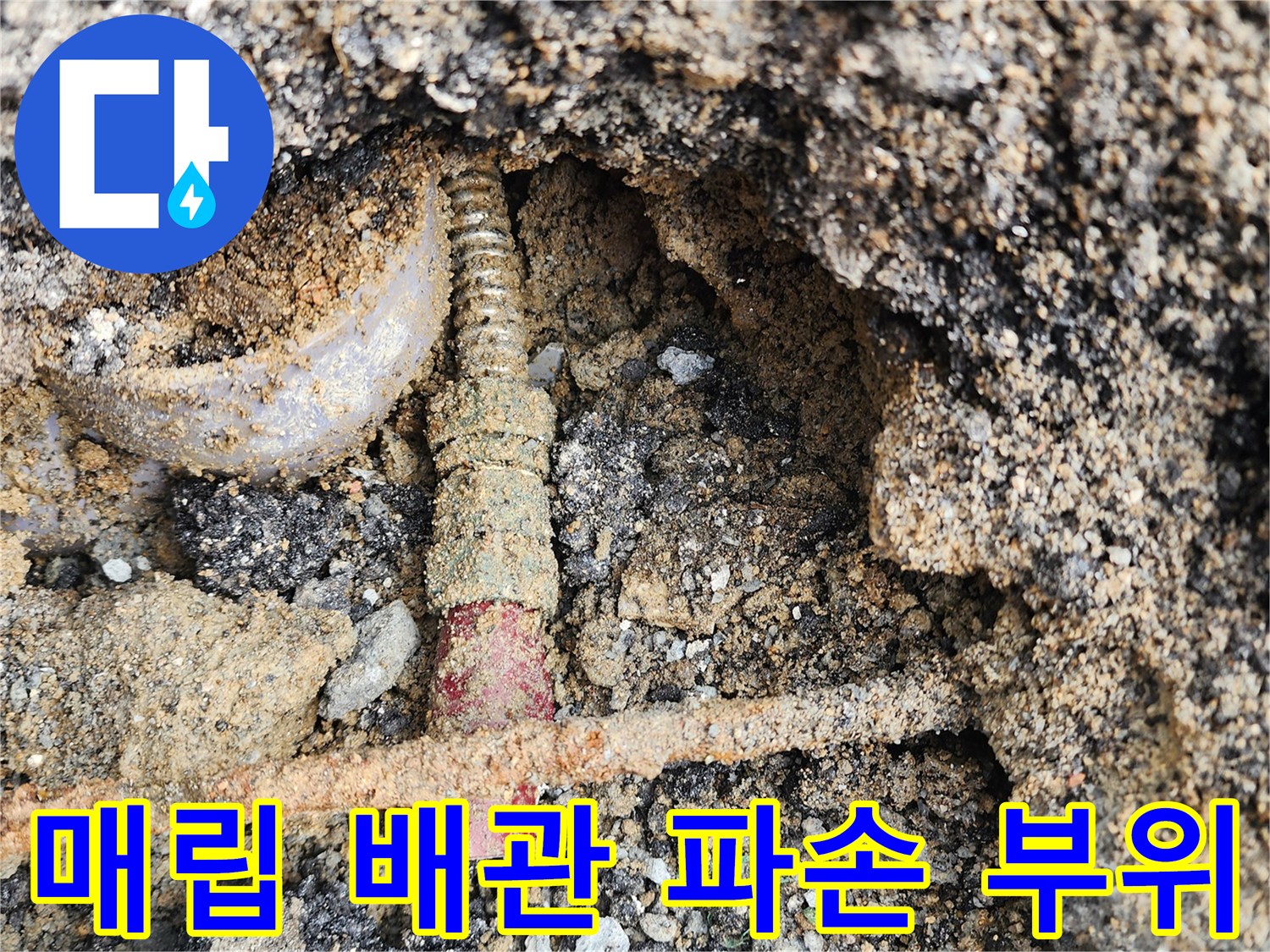 아스팔트 아래 드러난 붉은색 배관