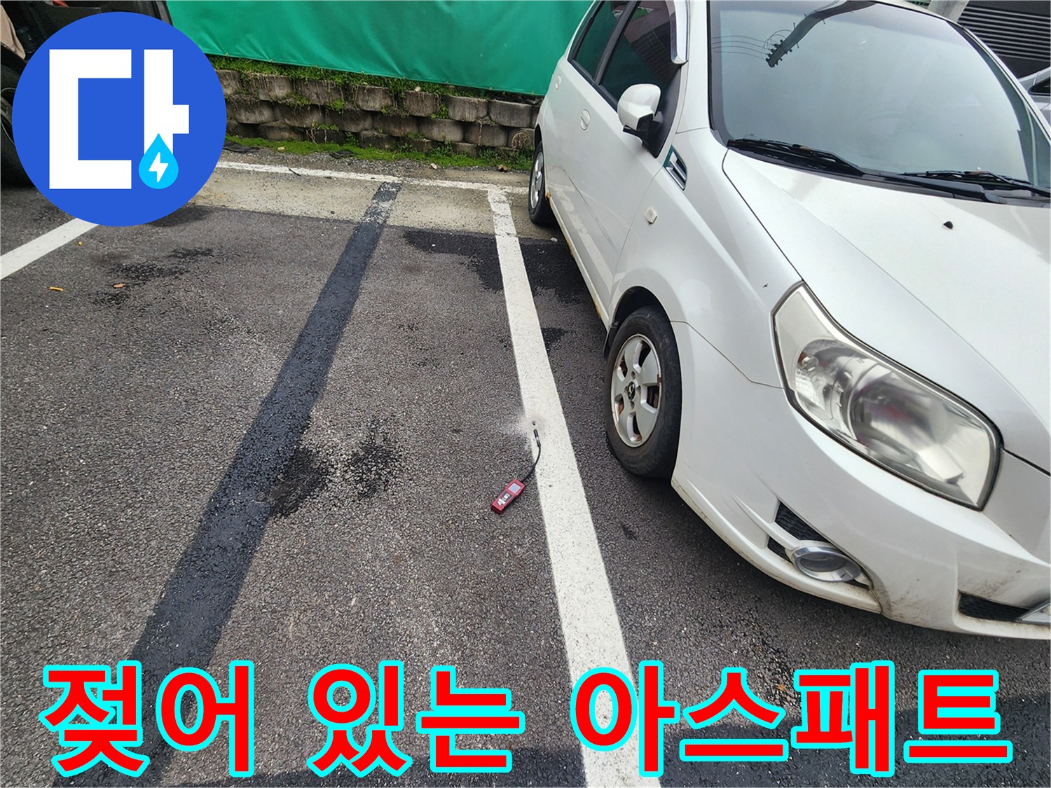 주차 라인 옆으로 번진 물기 흔적