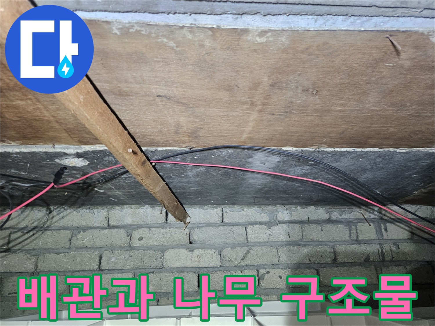 천장 내부의 배관-및-나무 판재 모습