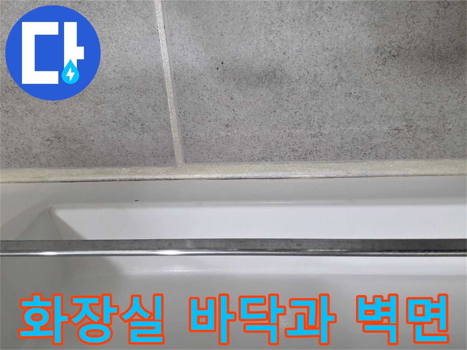 회색 타일 바닥과 스테인리스 수건걸이 하단