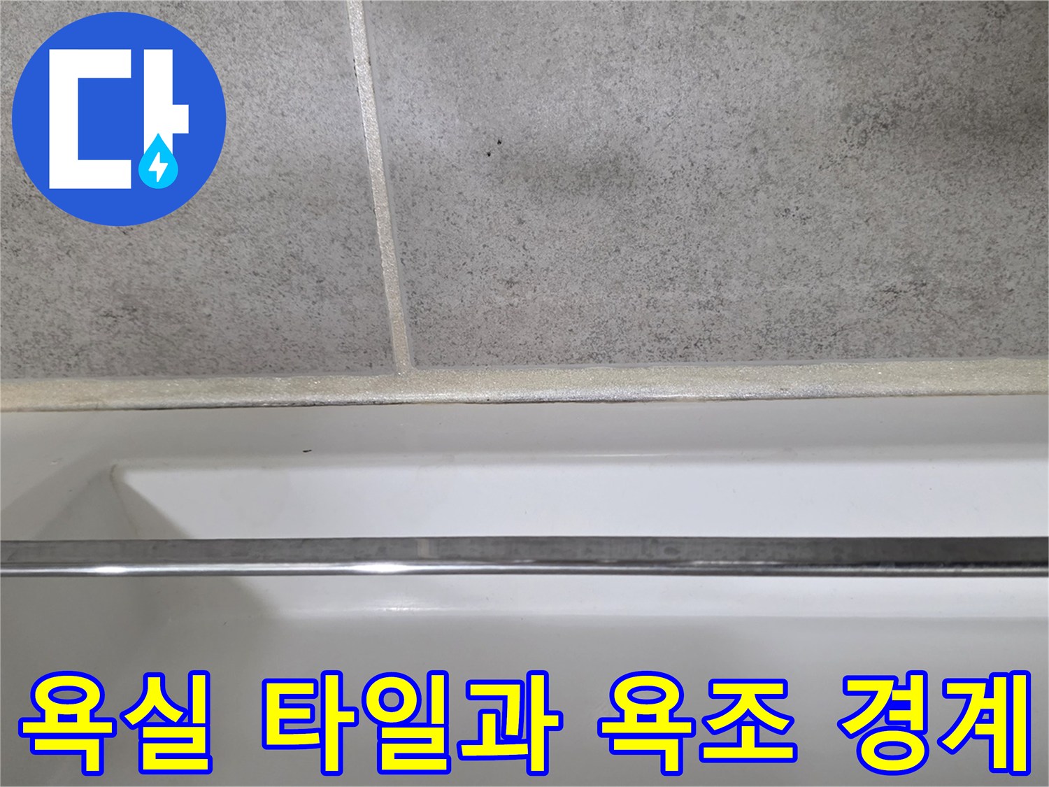화장실 타일과 하얀색 욕조 테두리의 접합부